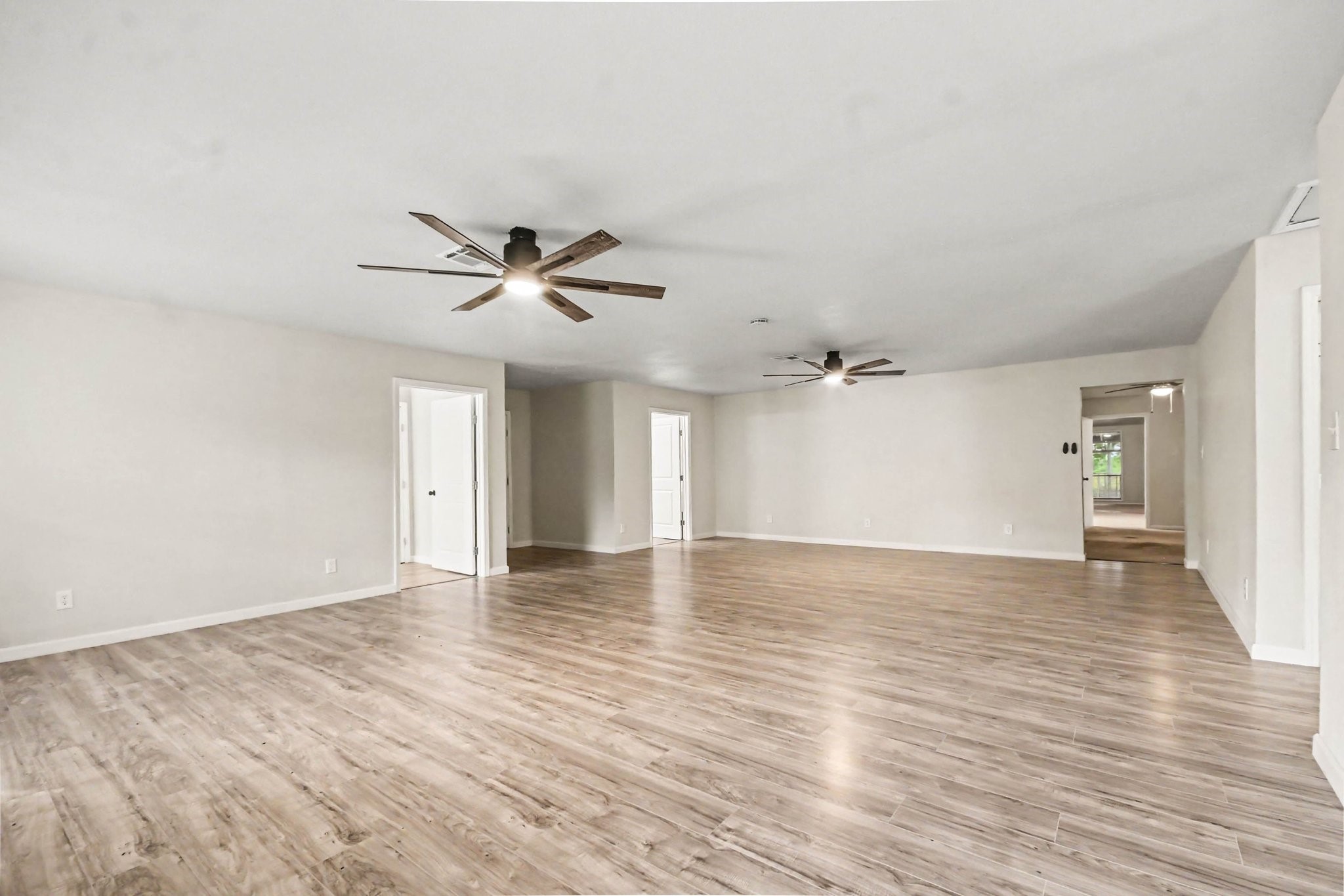 Giant game room has ceiling fan, new plank flooring, new paint