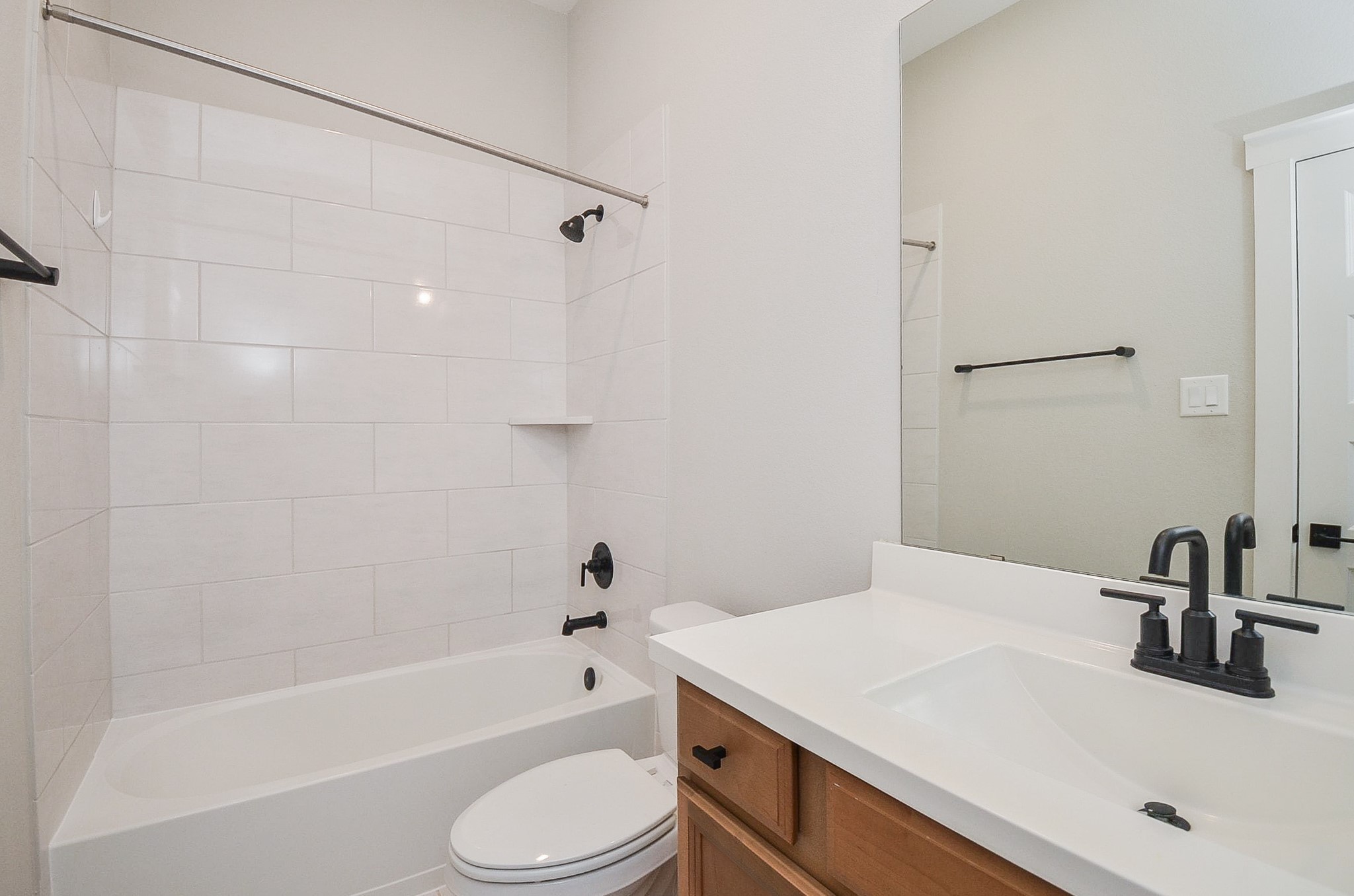 Secondary bath features a tub-and-shower combination with crisp, functional finishes.