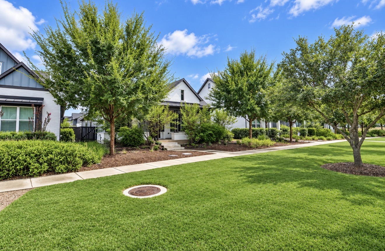 Spacious front yard with mature trees and lush landscaping.