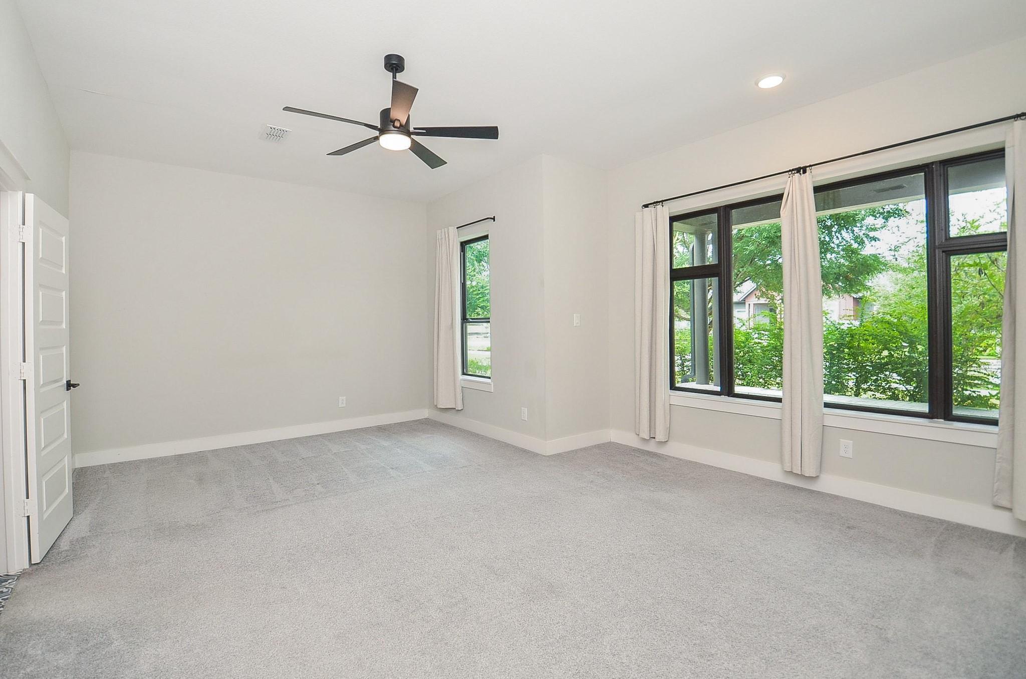 Serene primary retreat pairs generous proportions with large windows and calming neutral finishes.