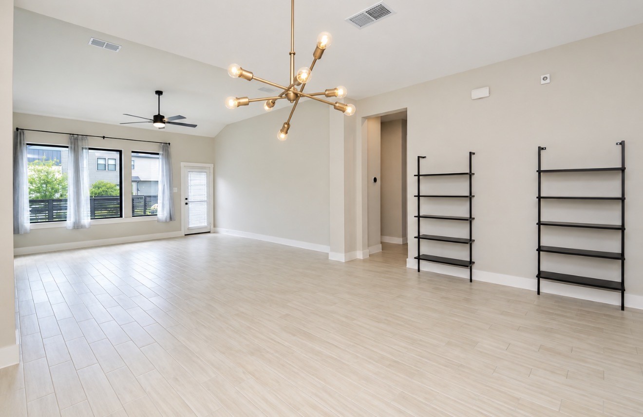 Spacious living area featuring abundant natural light and built-in shelving.
