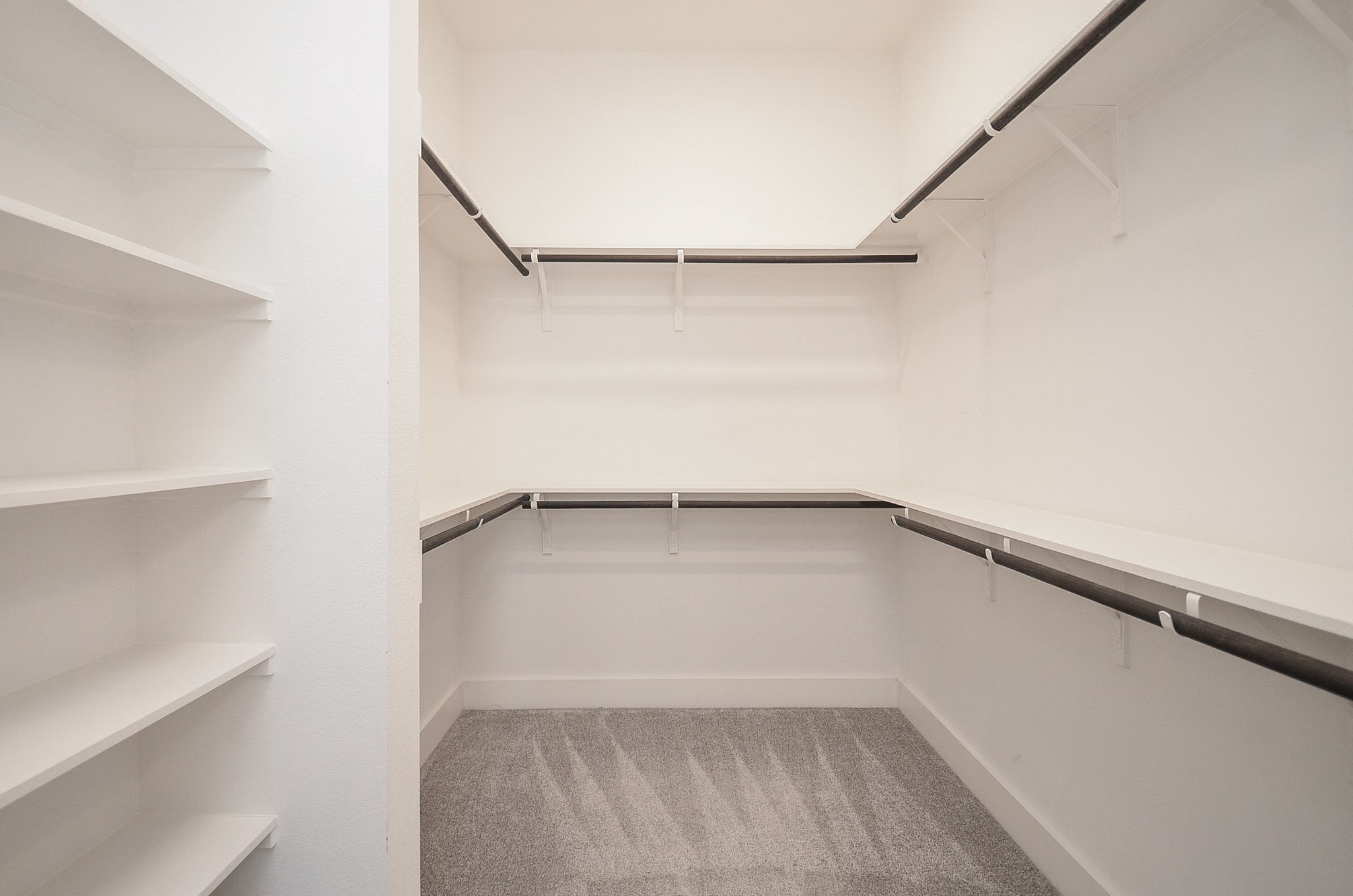 Walk-in wardrobe delivers organized storage with built-in shelving and abundant hanging space.