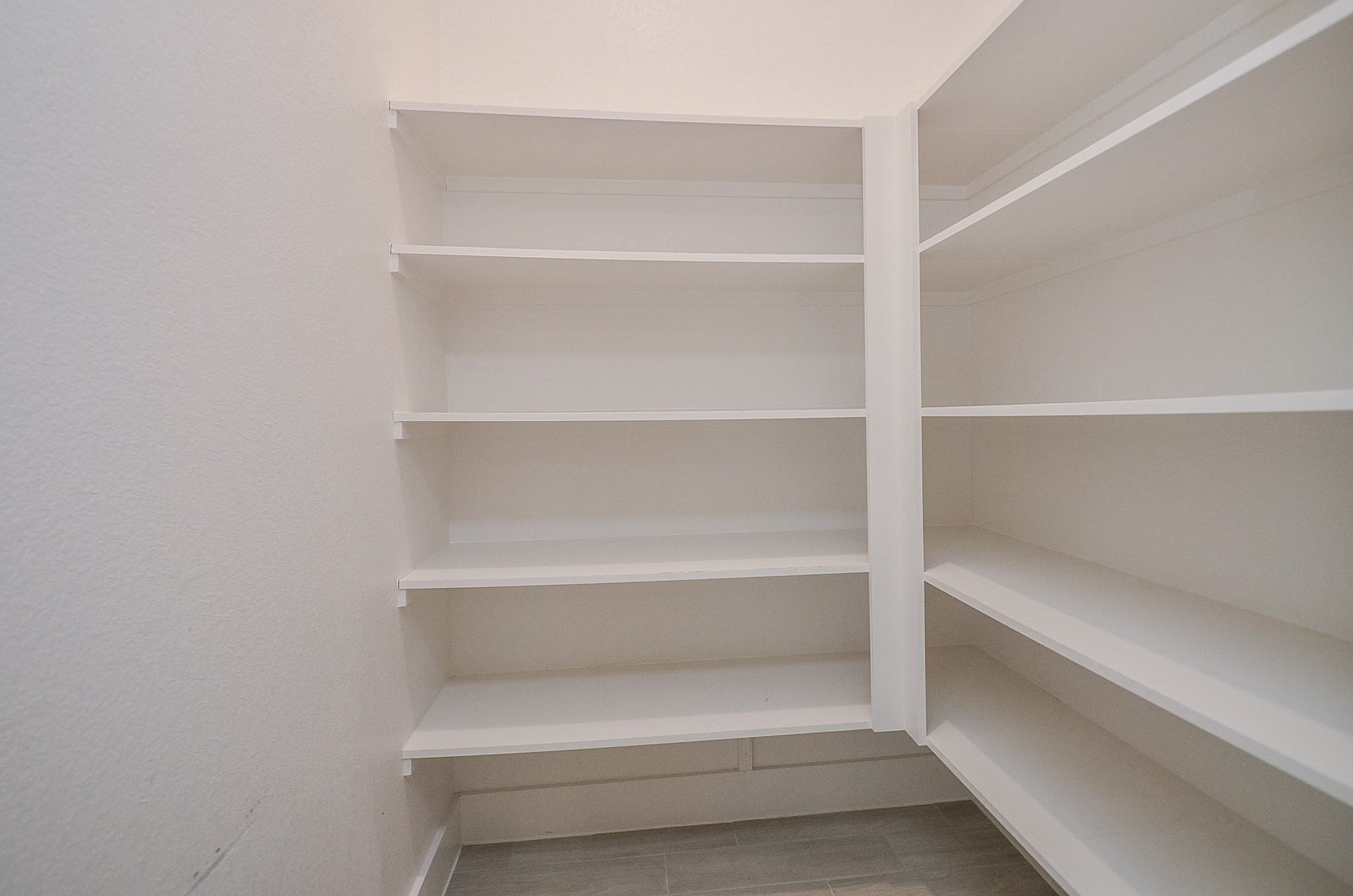 Walk-in pantry provides generous shelving and convenient storage to keep kitchen essentials organized and within easy reach.