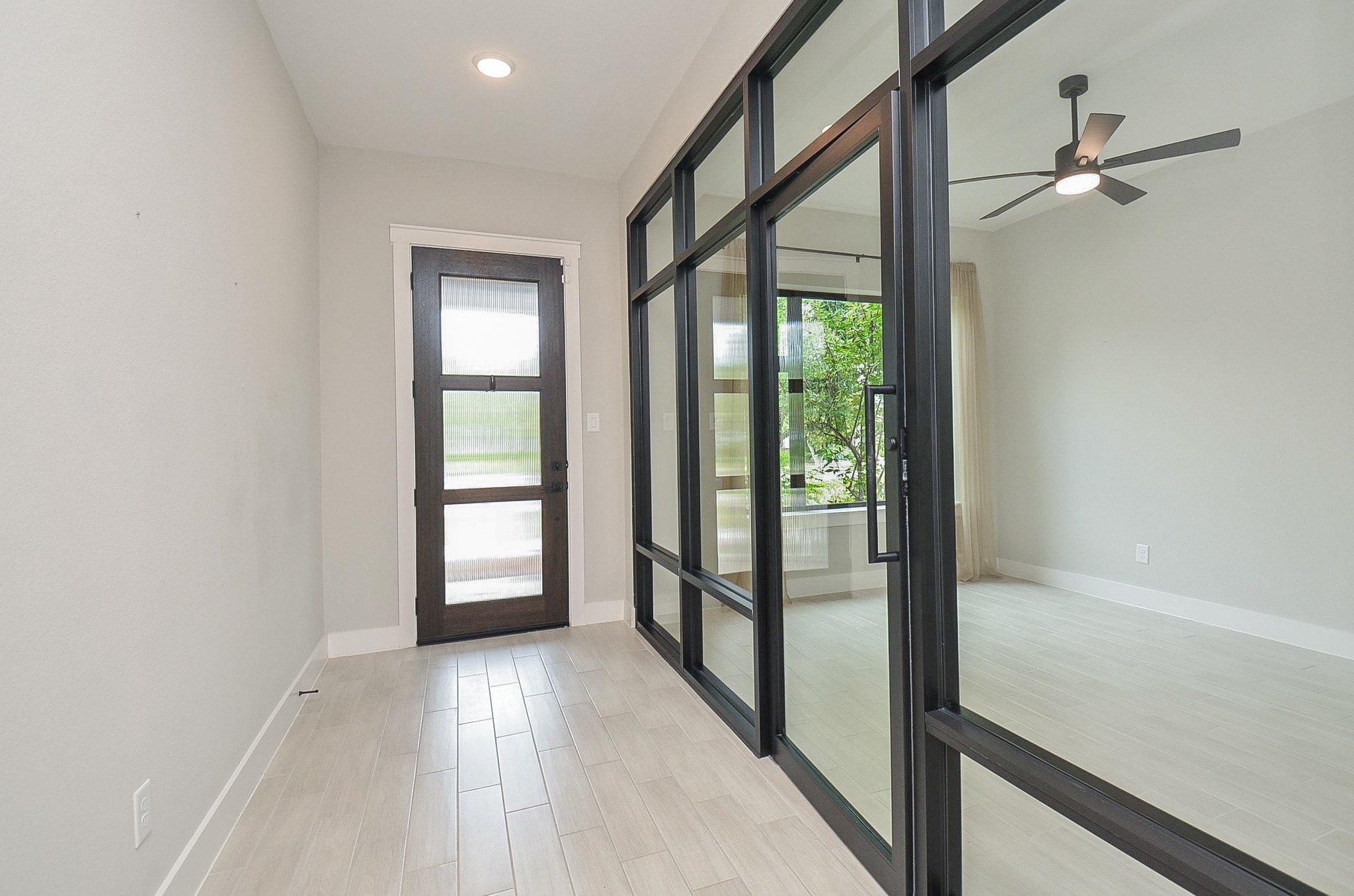 Statement black-framed glass doors introduce a sleek, modern element upon arrival.