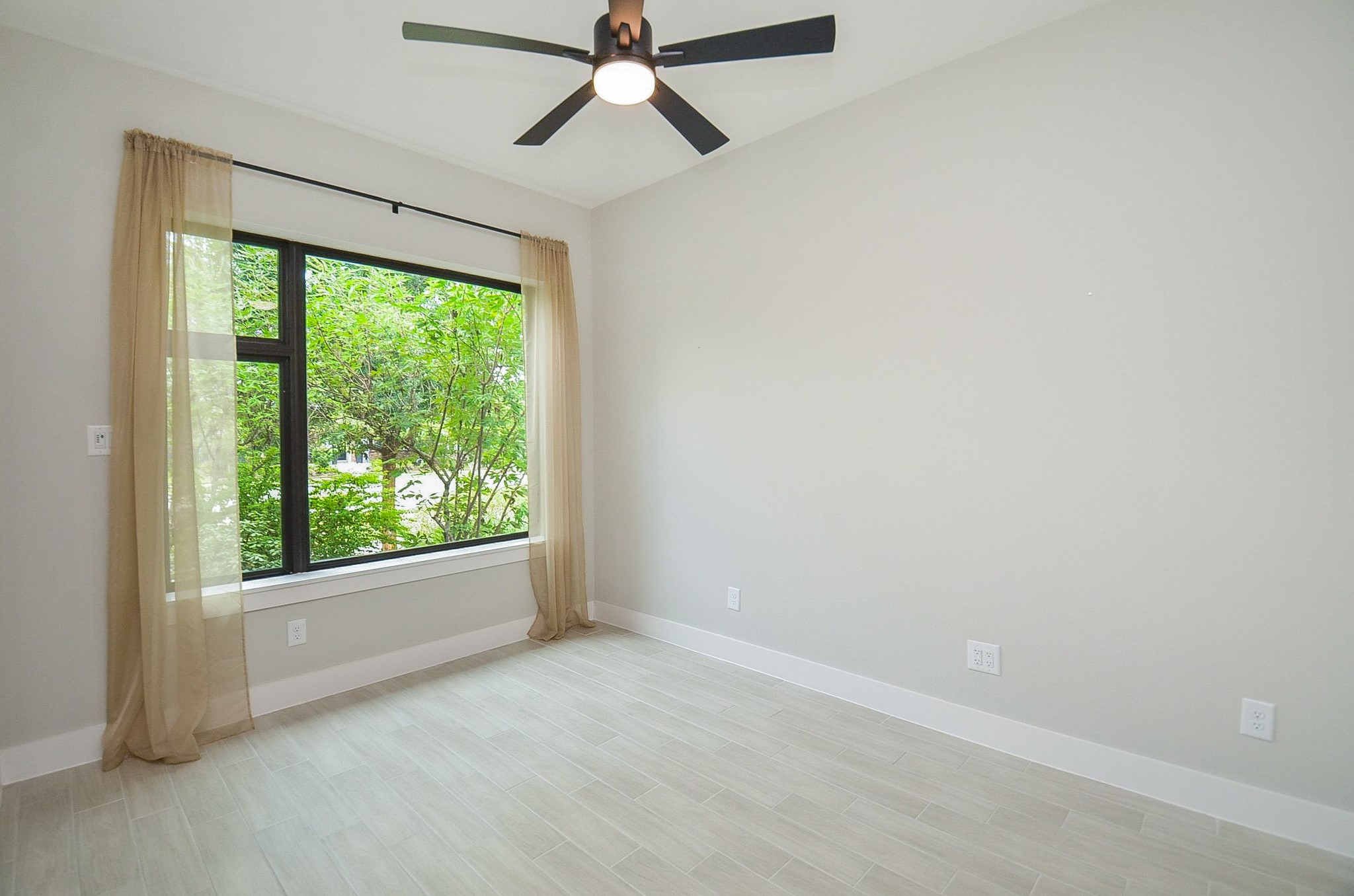 Large window brings outdoor views into this inviting secondary bedroom.