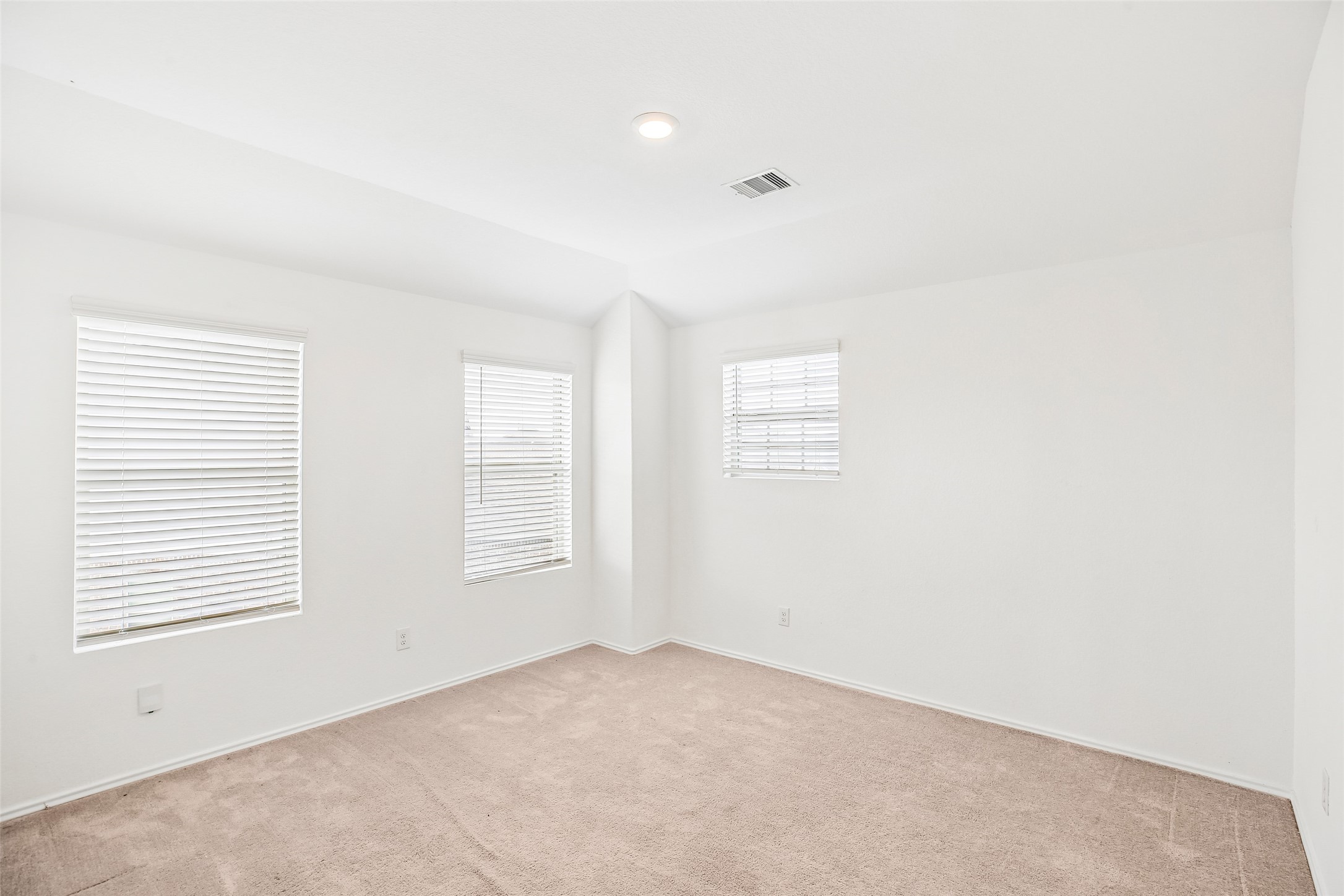 Upstairs family room with three windows, blinds, recessed lighting, and existing carpet.