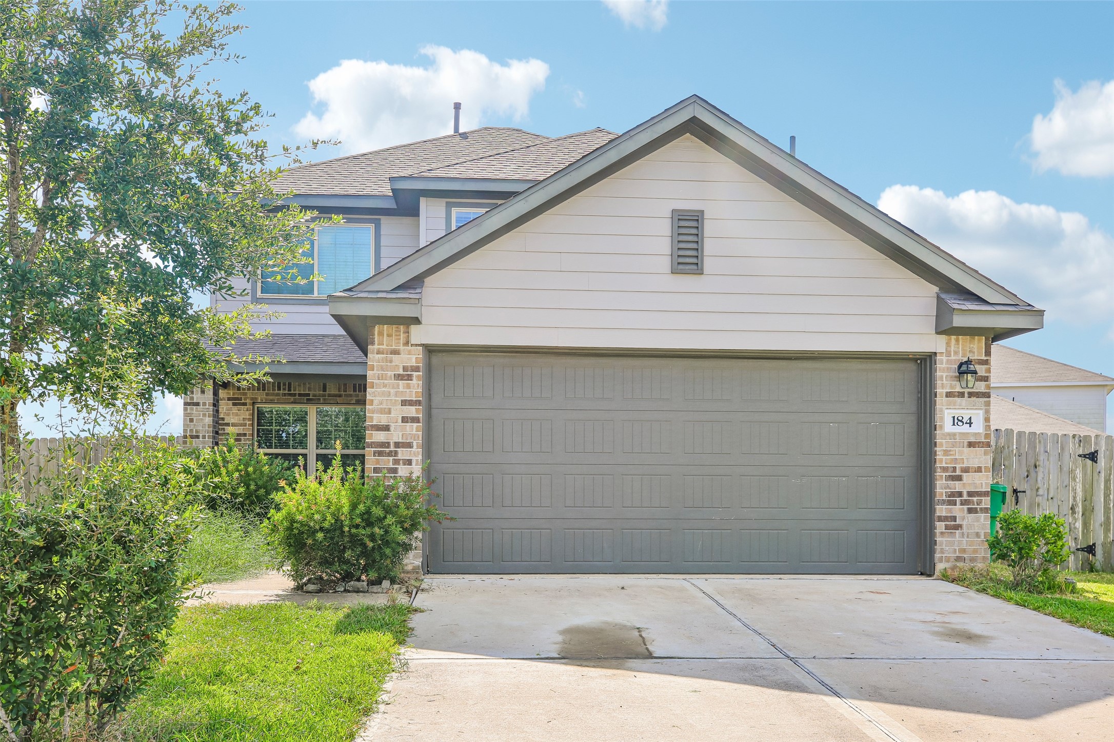 Front exterior view showing the attached garage, driveway, landscaping, and house facade.