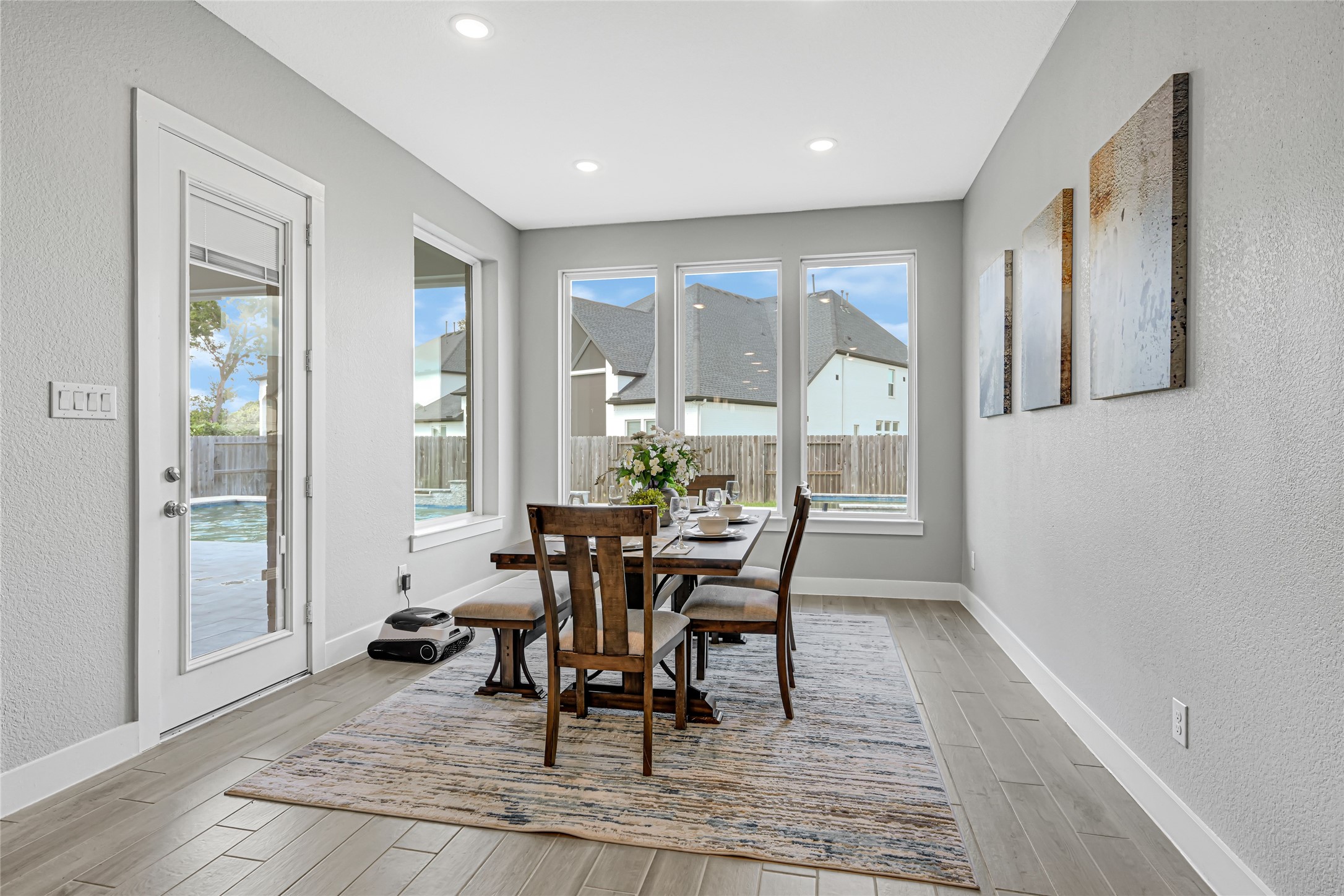 Bright dining area overlooking the backyard and pool.