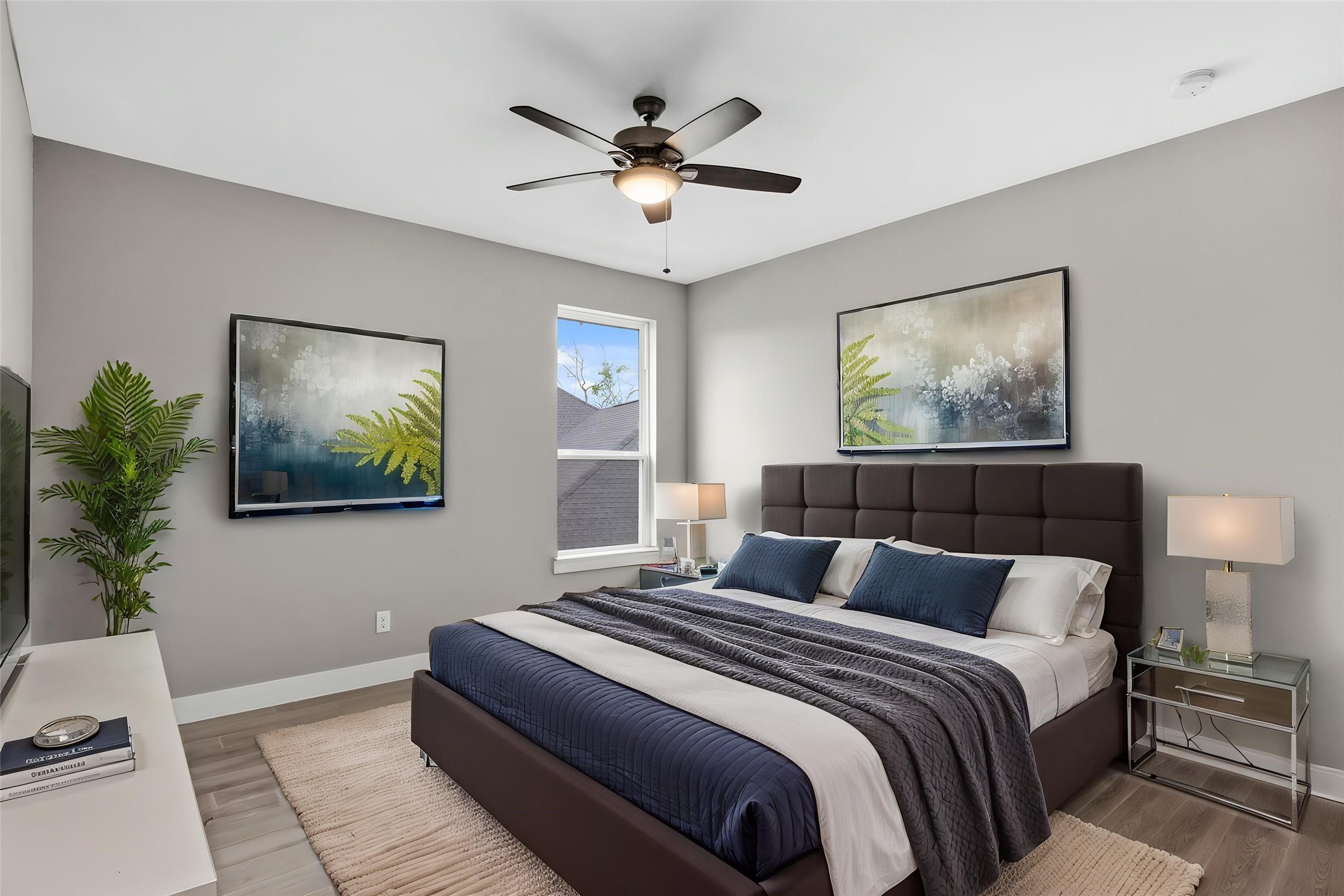 Spacious secondary bedroom with large windows and ceiling fan.