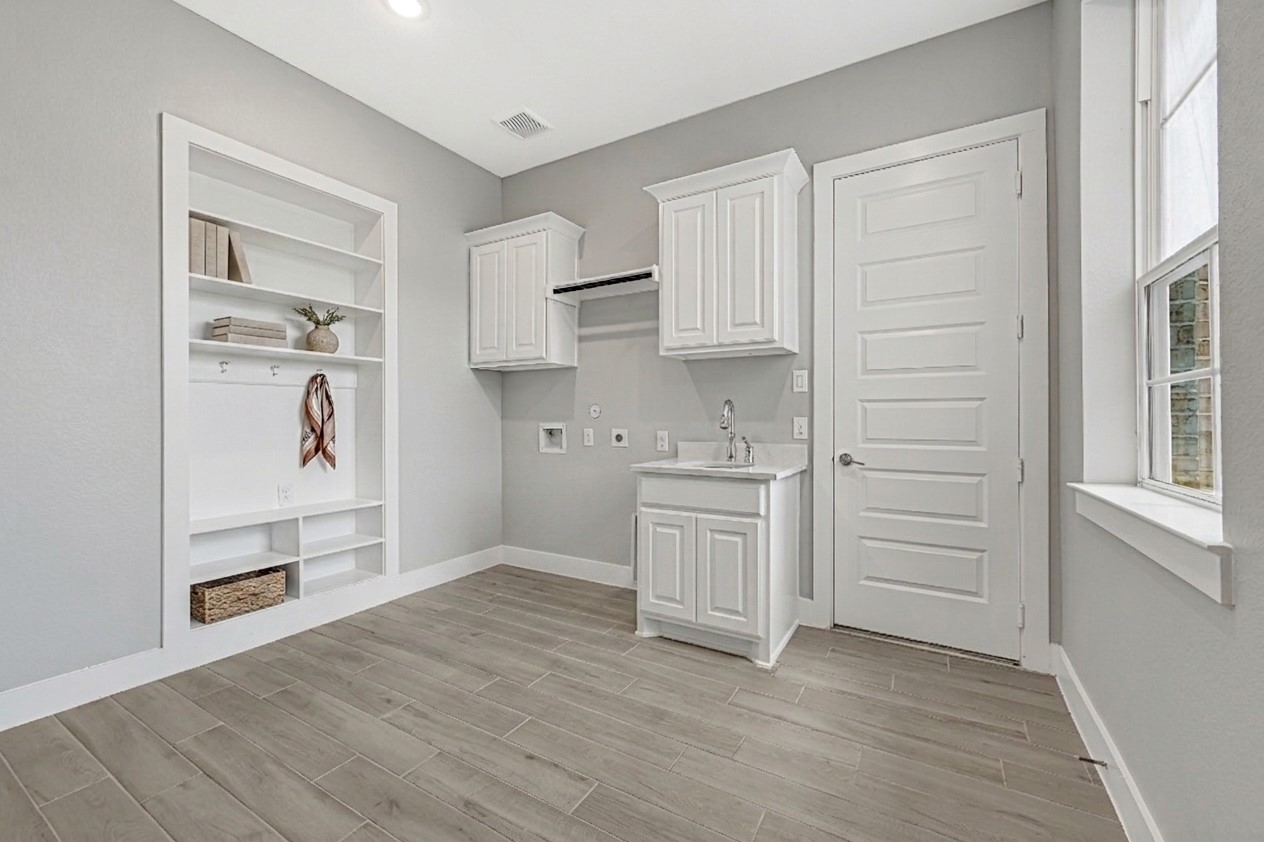 Laundry room with additional sink and upgraded cabinets