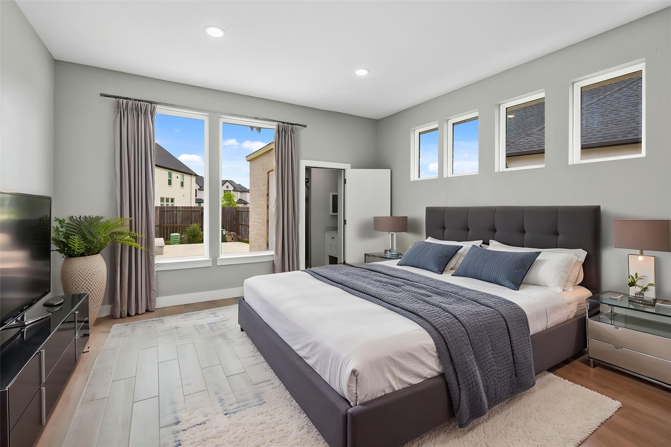 Bright bedroom featuring large windows and ample living space.
