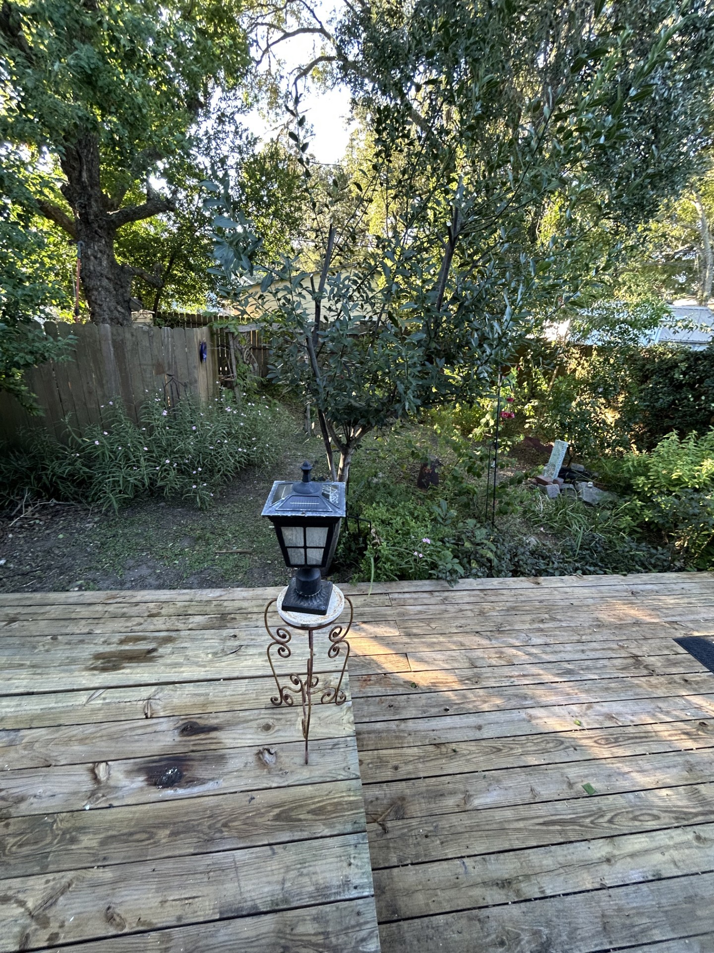 Looking from backdoor into the backyard showing two levels of decks and the native plant aspect of the backyard.  No watering required!