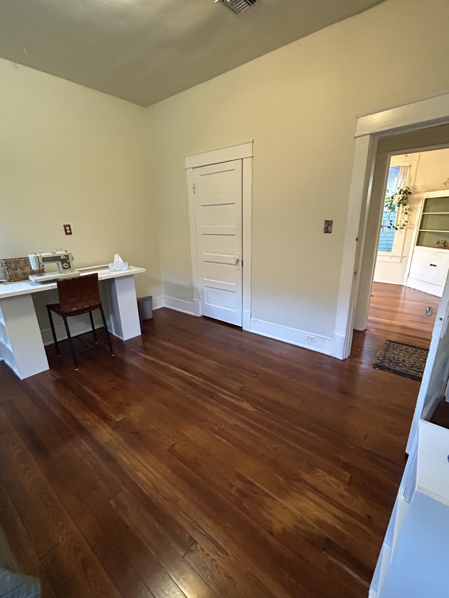 Middle bedroom with view from bedroom door across the hallway into the dining room.