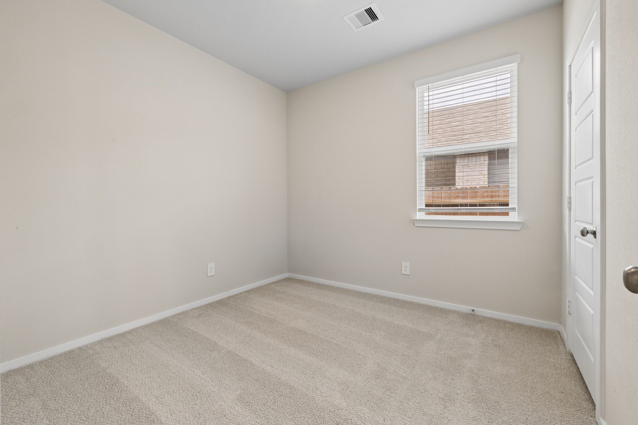 Cozy bedroom featuring soft, neutral carpeting and a window providing natural light.