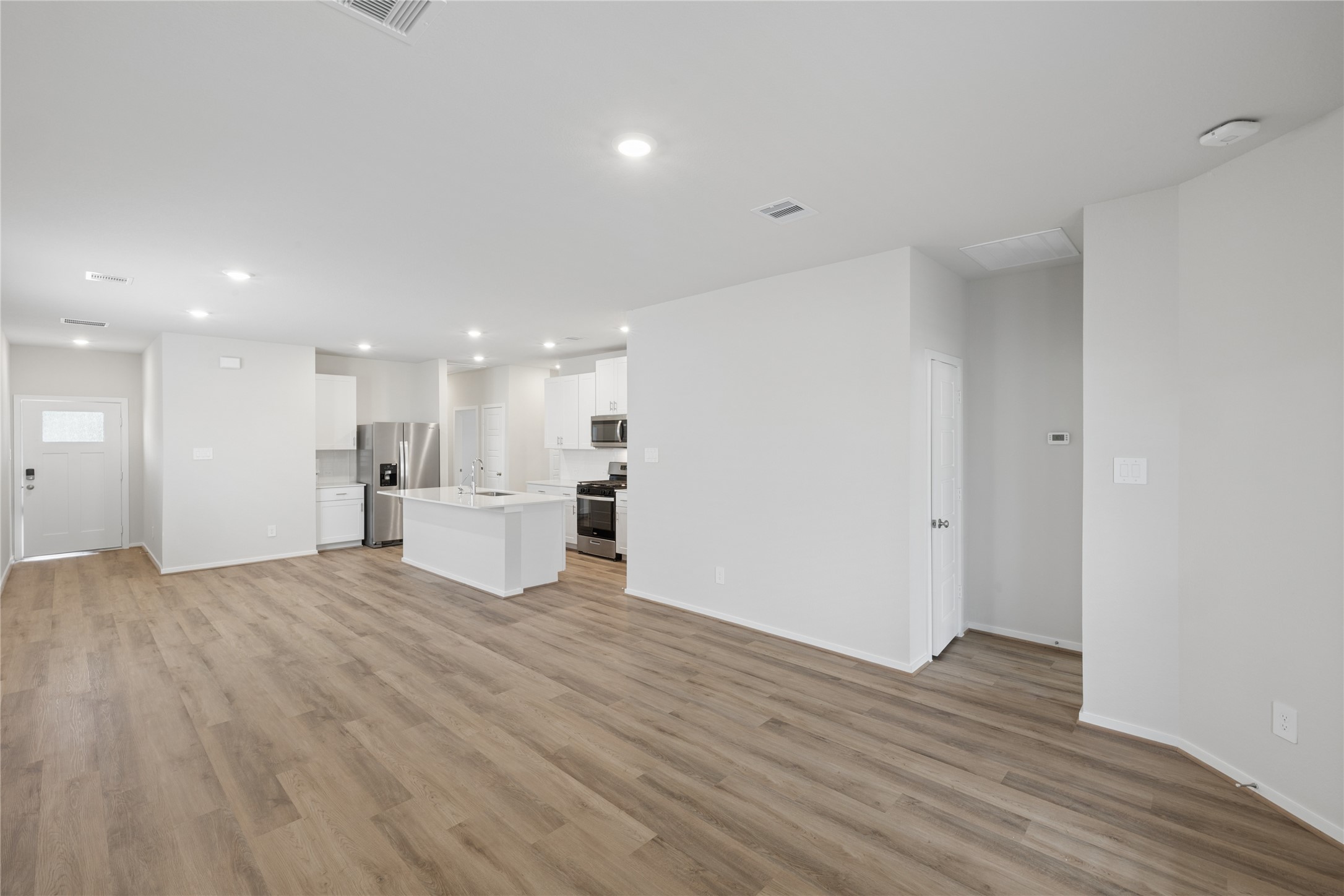 Spacious open-concept living area featuring modern kitchen with stainless steel appliances, sleek countertops, and ample natural light.