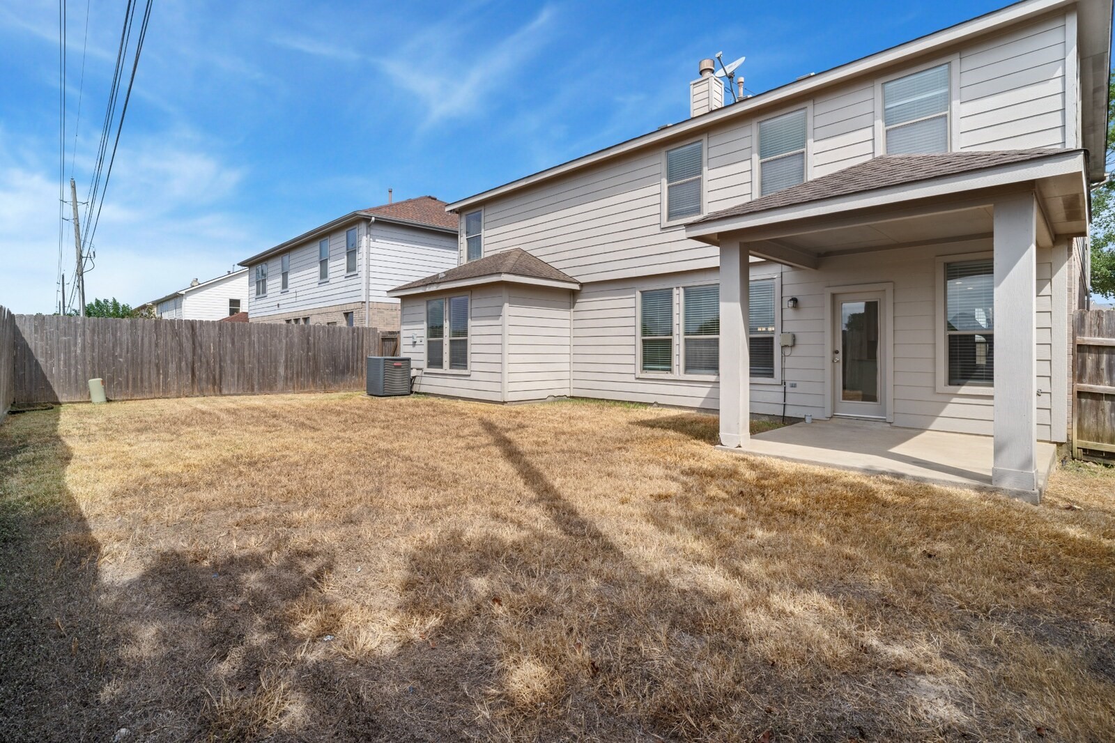 Backyard  Fenced backyard provides an open lawn area and a covered patio directly accessible from the home, offering flexible space for outdoor seating and recreation.