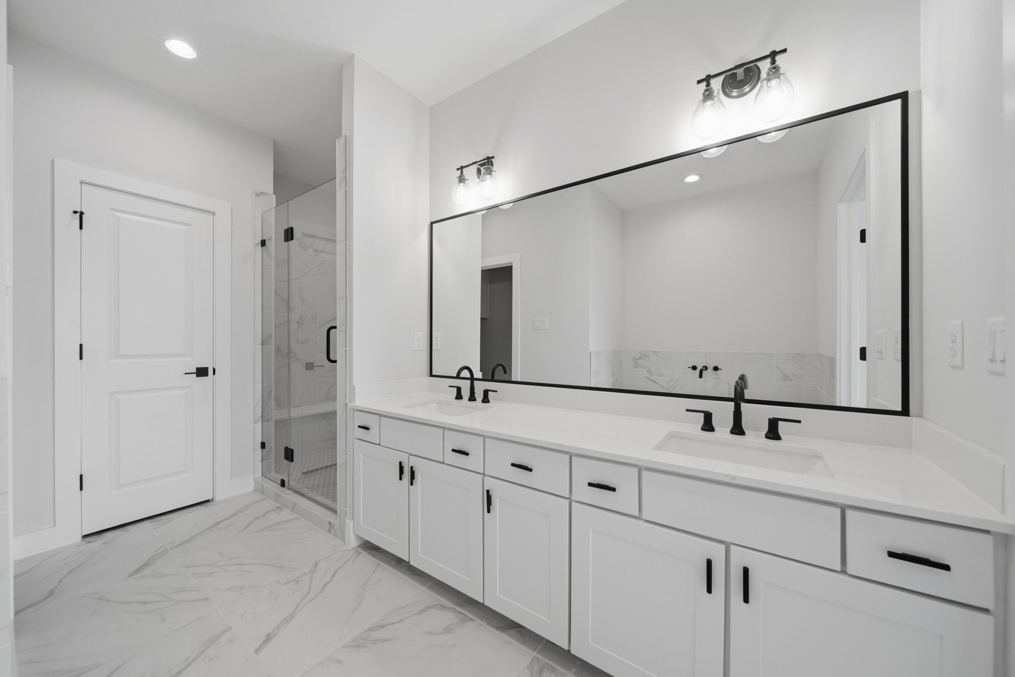 Primary bathroom with dual sinks, standing shower, & a soaking tub.
