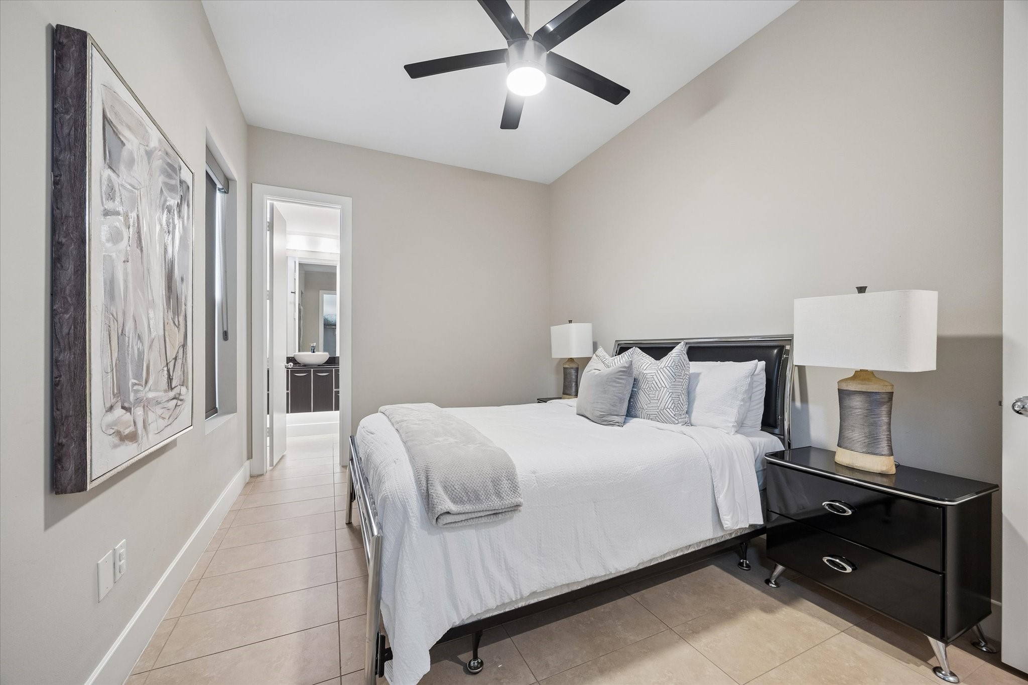 The first-floor guest suite gives the home a wonderfully flexible layout, with a private bedroom, walk-in closet, ensuite bath, and nearby utility room all tucked together for convenience. It is a great setup for overnight guests, a quiet home office, a workout space, or anyone who wants comfortable separation from the main living areas.