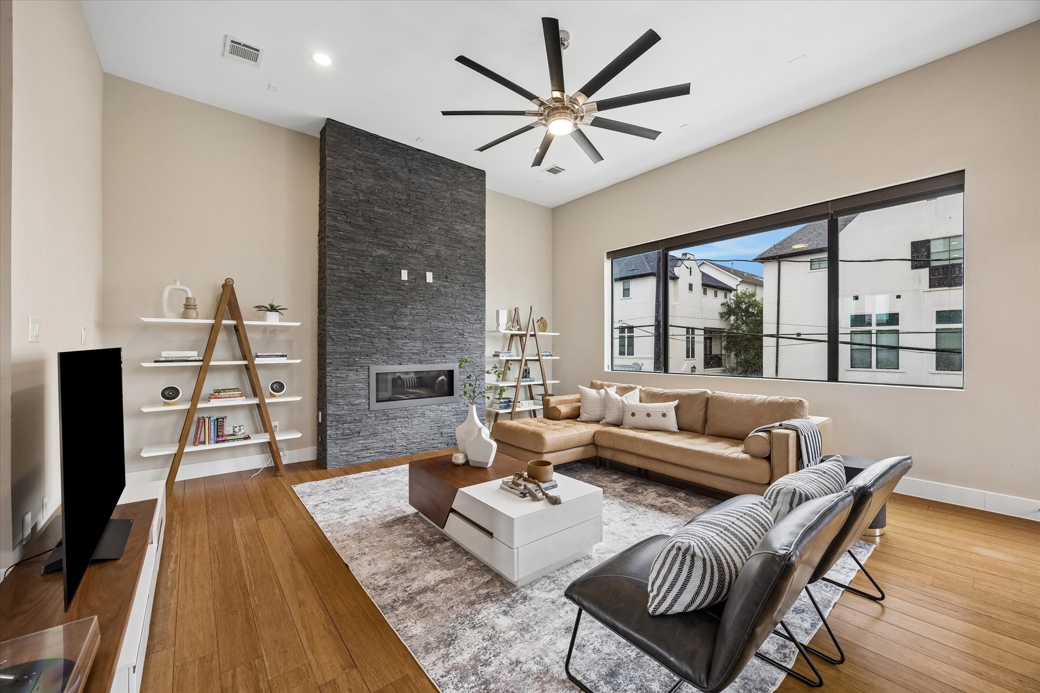 The sunken living room feels bright, modern, and welcoming, with warm wood flooring, wide windows with custom shades, and picture-perfect views that bring in beautiful natural light. This is an easy space to imagine relaxing, entertaining, or simply enjoying the comforts of home.