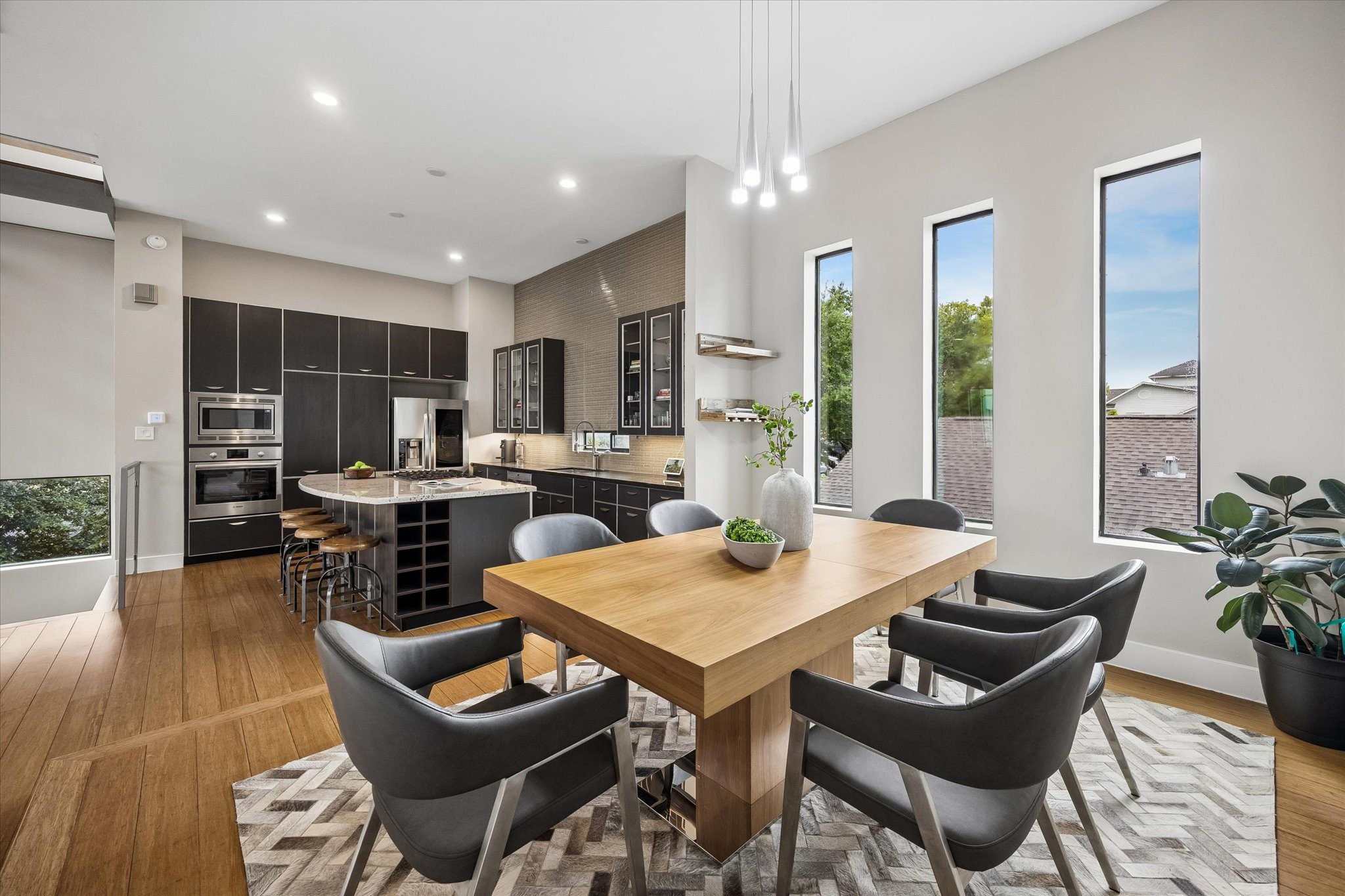 The second-floor offers an open, airy space where the dining room flows beautifully into the island kitchen, making the main living level feel connected and easy to live in. Tall windows, warm wood flooring, crisp finishes, and stylish lighting help the whole space feel fresh, inviting, and ready for gathering.