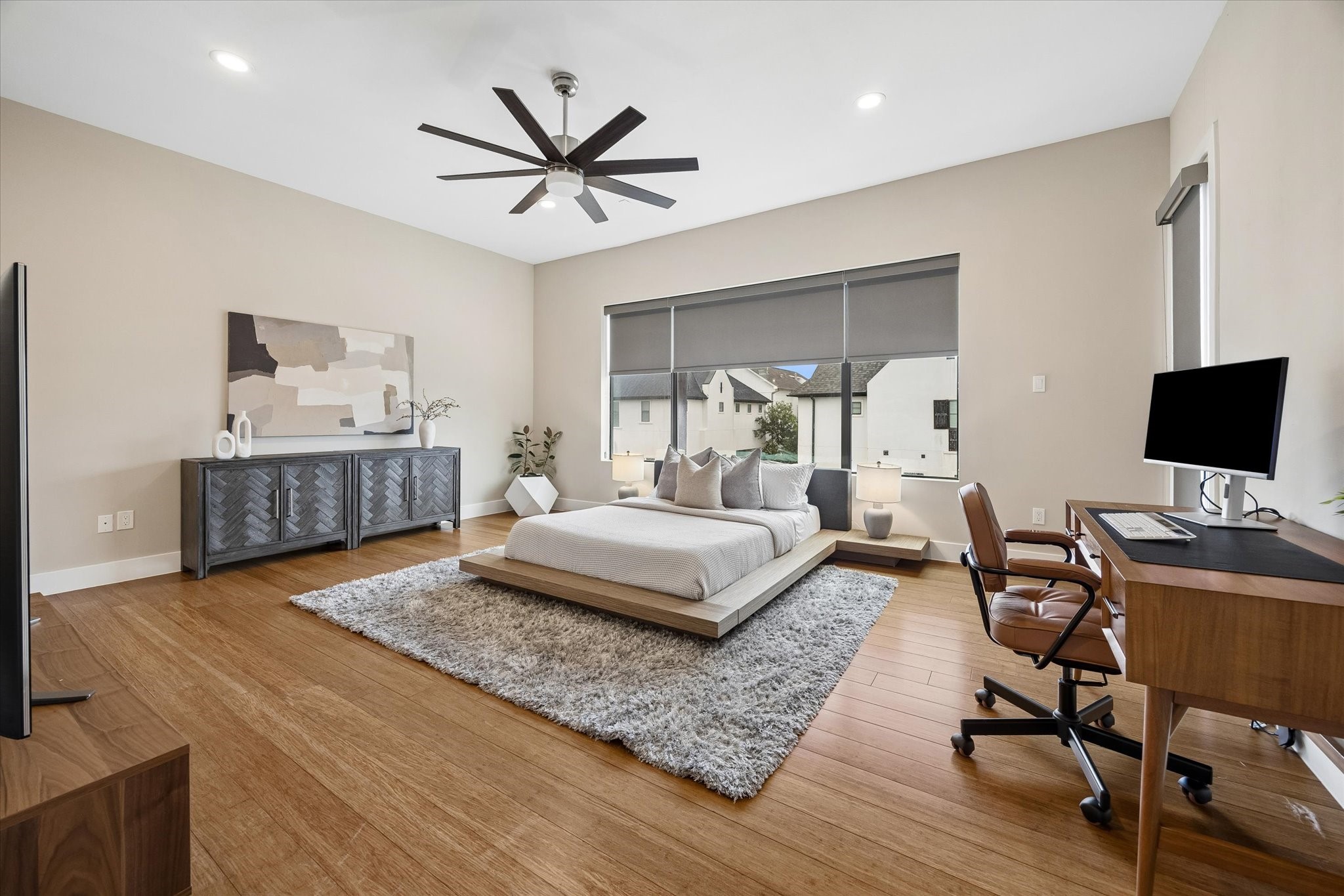 The third-floor primary suite feels spacious, calm, and beautifully polished with warm wood flooring, custom window shades, and plenty of room to stretch out and relax. With direct balcony access, a large walk-in closet, and a spa-like ensuite bath, its the perfect space to begin and end each day.