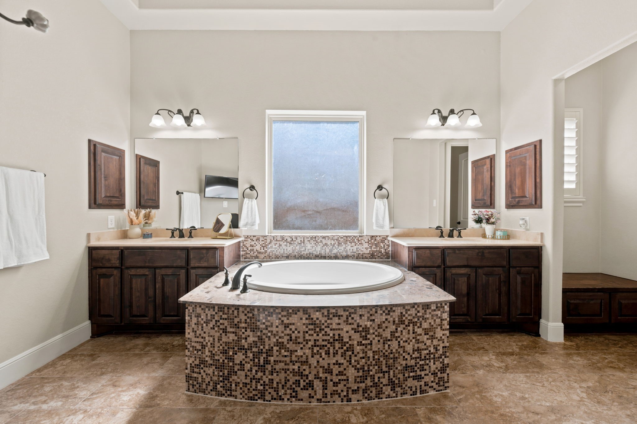 Primary bath with garden tub and dual vanities.