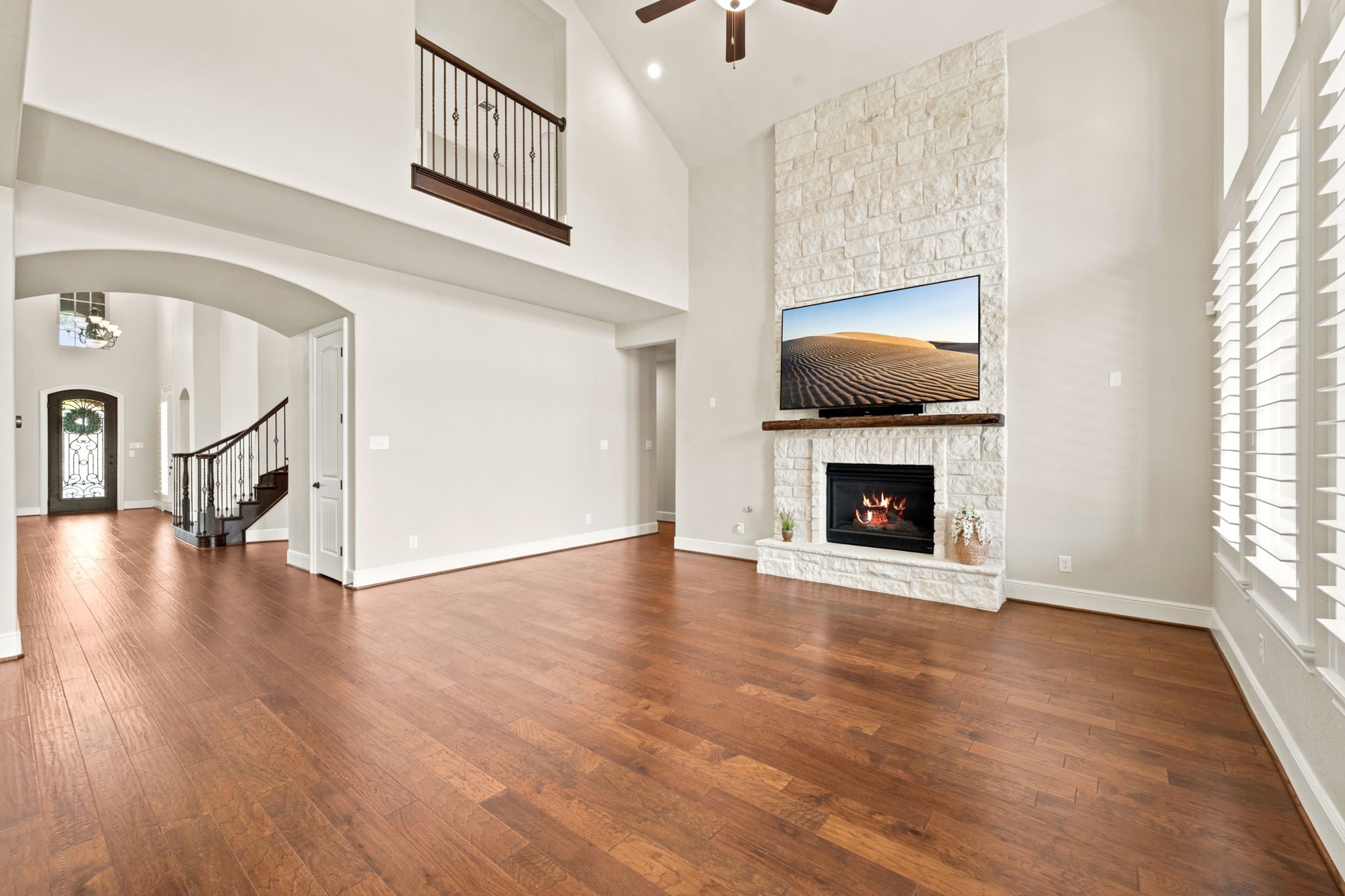GREAT room/living room with surround sound speakers, stone fireplace, engineered wood flooring (NOT LVP)