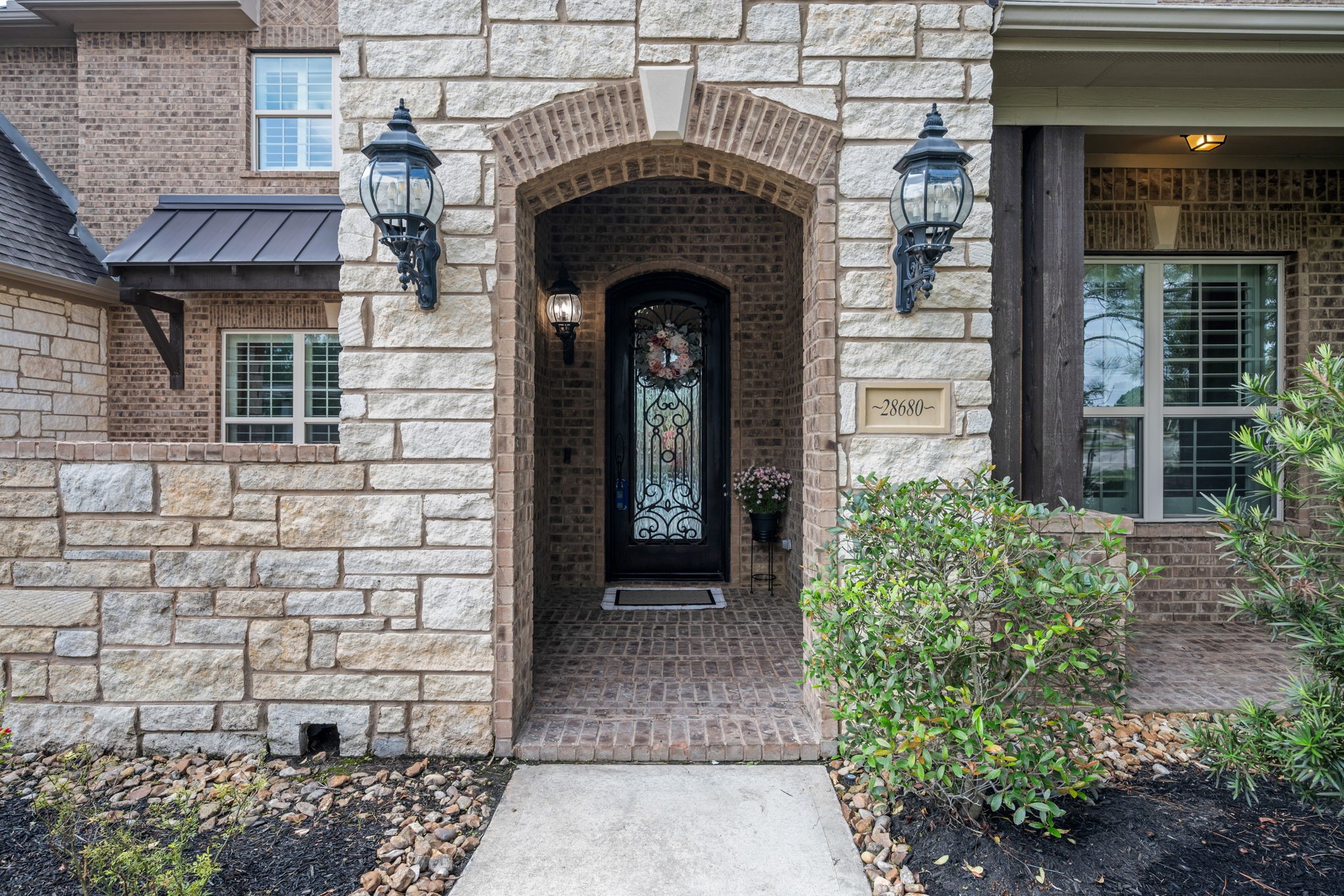 Grand Stone/Brick front entry with a covered front porch.
