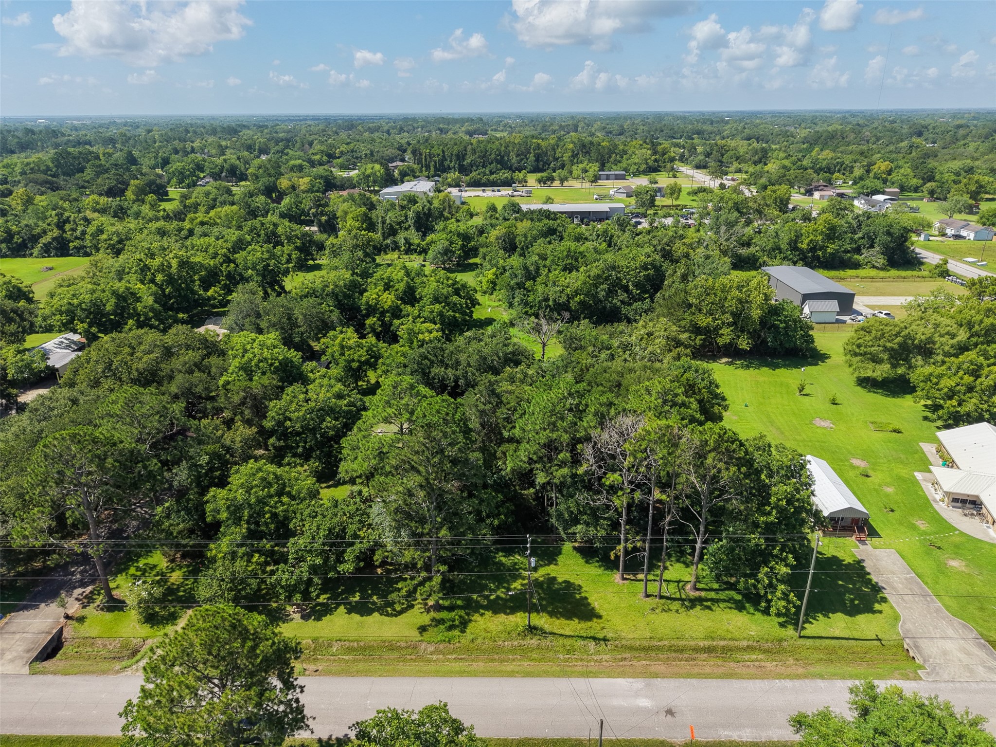 From above, the combination of wooded and open portions of the tract becomes especially apparent. Mature trees offer the opportunity to preserve natural shade and privacy around a future homesite, while less densely wooded sections may provide flexibility when planning improvements. With approximately 111' of road frontage and 612' of depth, the property offers considerably more breathing room than a conventional residential lot.