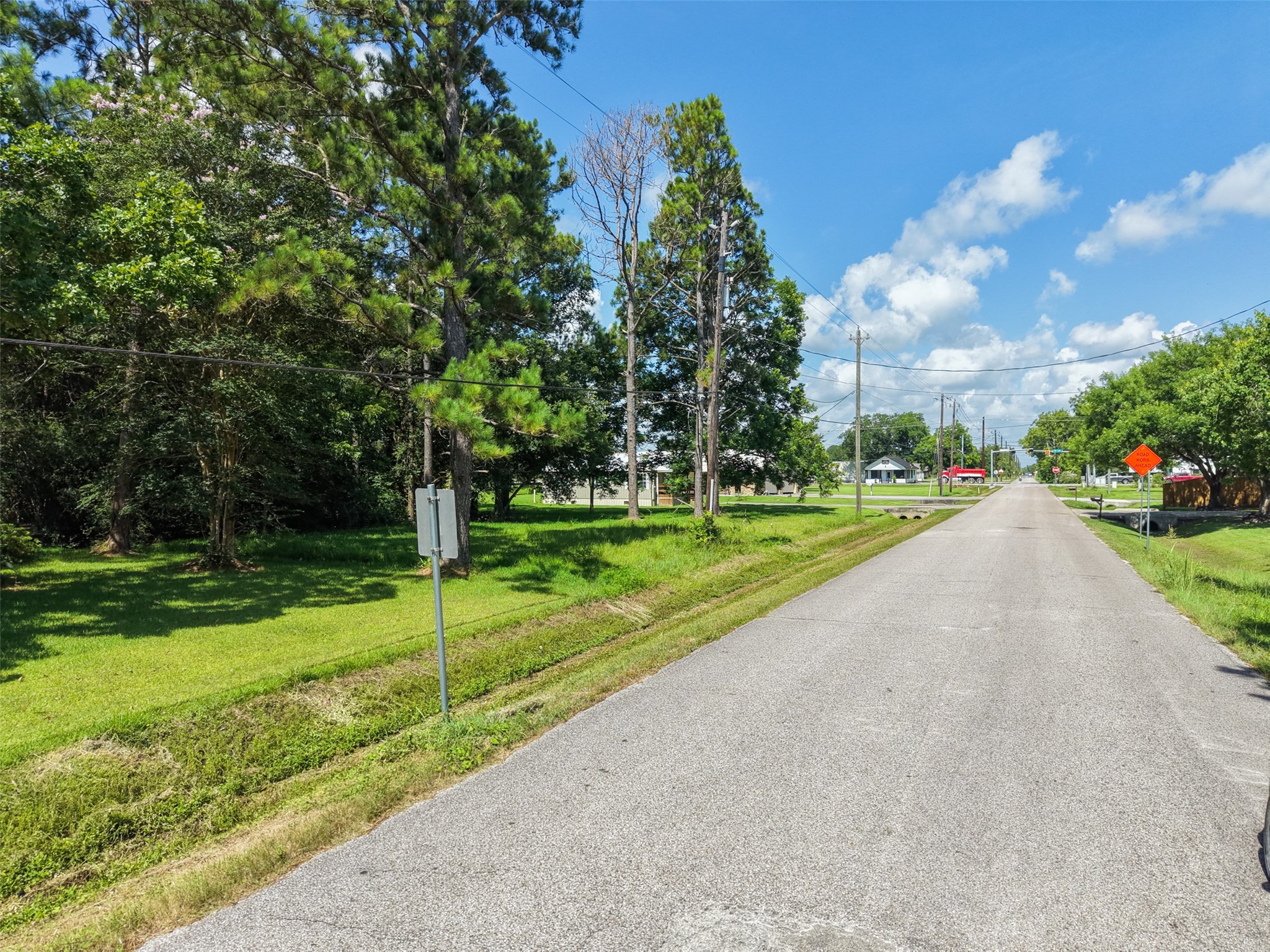 Street-level view along 28th Street highlights the property's peaceful country setting and convenient paved access. Mature trees line the roadway and contribute to the area's established rural character, yet the homesite is positioned just off FM 646 for easy connections throughout Santa Fe. This location offers an appealing balance between privacy and accessibility rather than requiring a long drive down remote country roads.