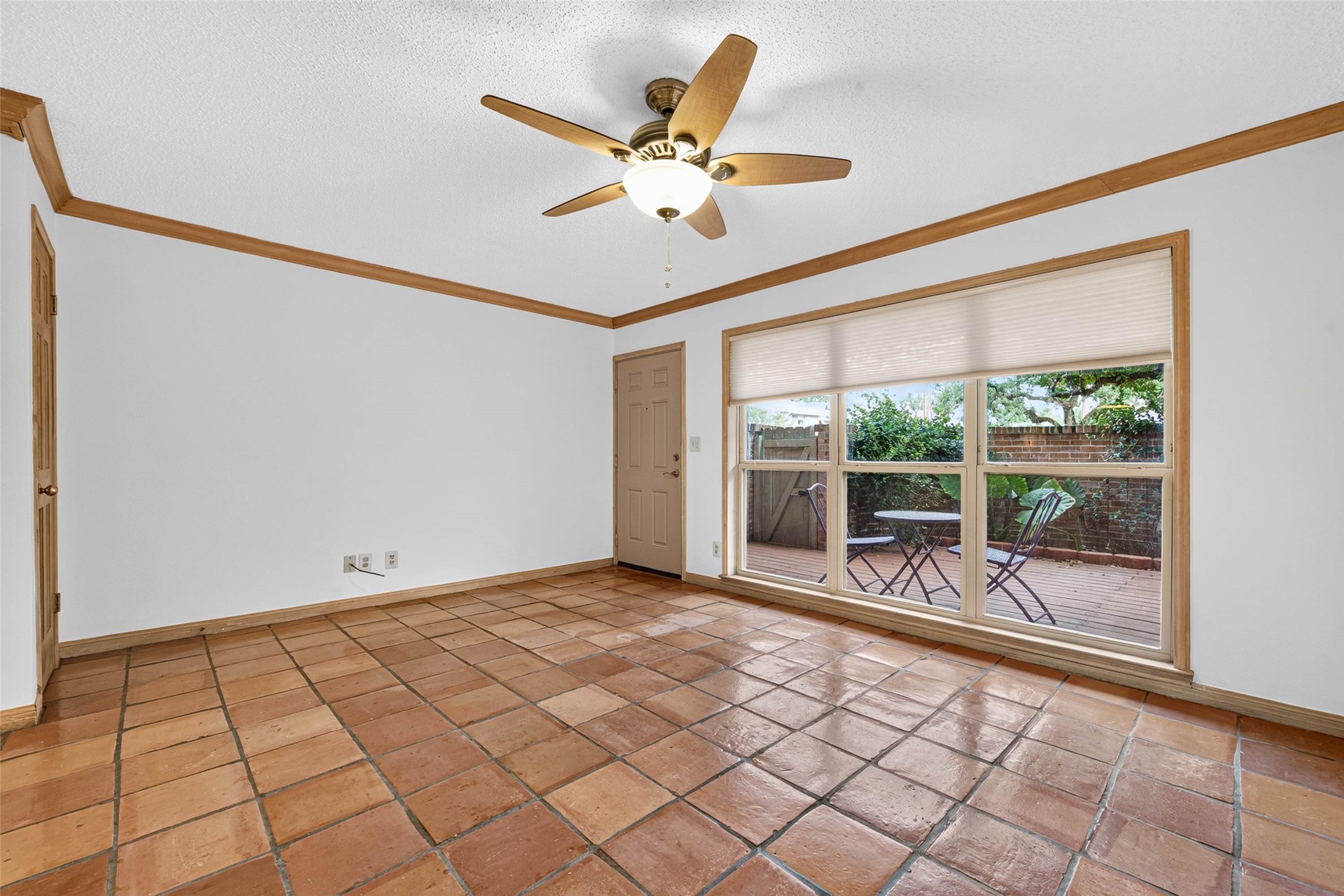 Spacious living area and large windows offering a view of the private outdoor patio.
