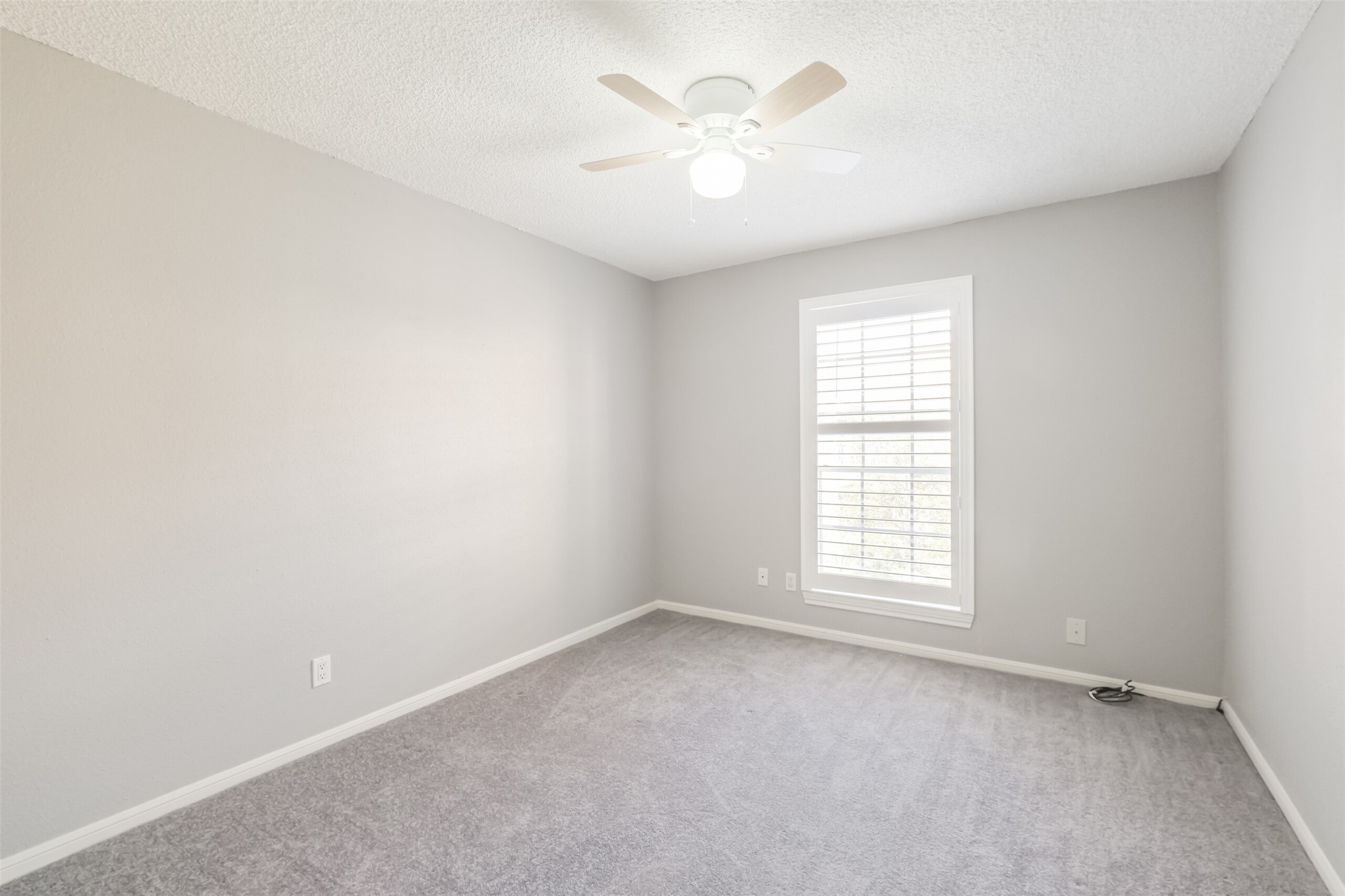 Comfortable secondary bedroom featuring carpet and a ceiling fan!