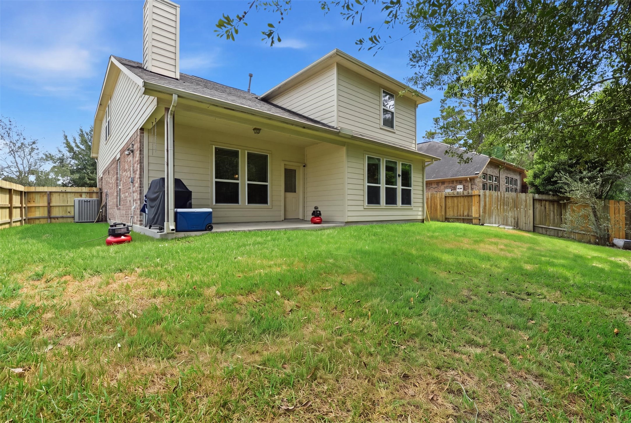 Your backyard escape: a covered patio, a fully fenced yard and room to grill, garden and unwind, with green space just beyond the fence.