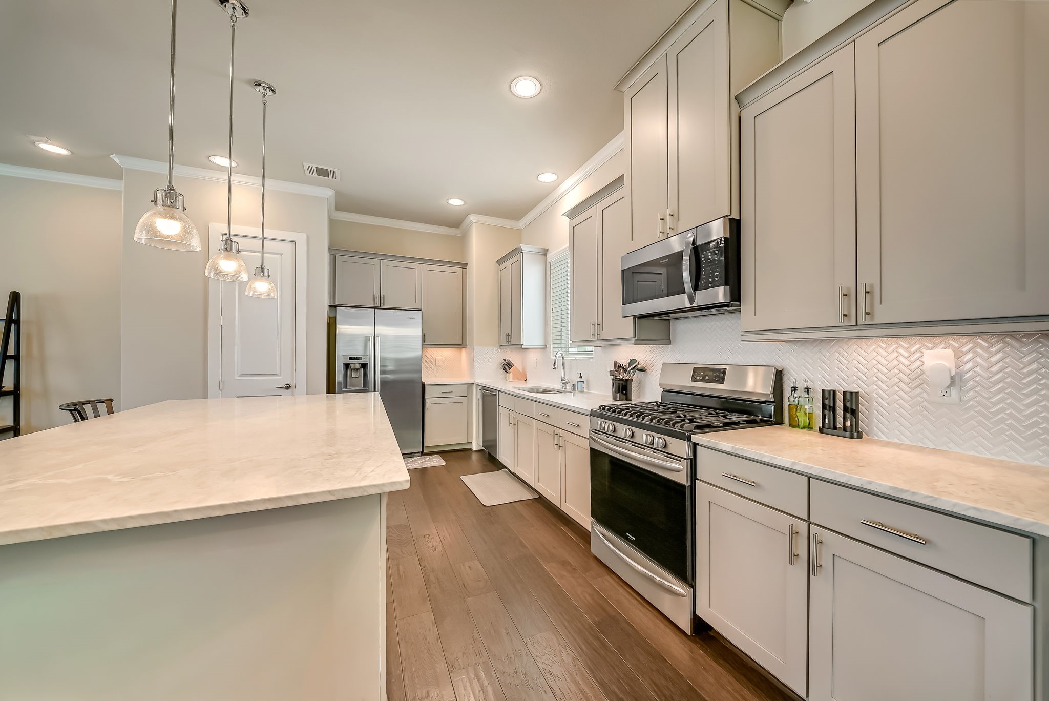Gourmet kitchen with extensive prep space, under-cabinet lighting, deep sink, five-burner gas cooktop, and abundant storage.
