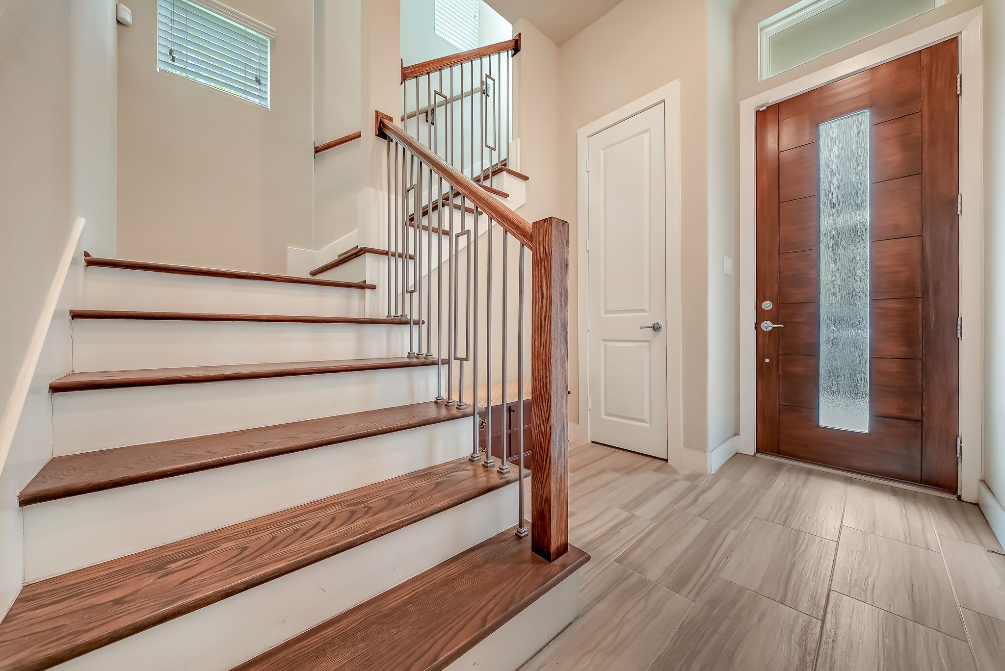 Dramatic two-story entry with hardwood stairs and an inviting foyer that sets the tone for the home's modern design.