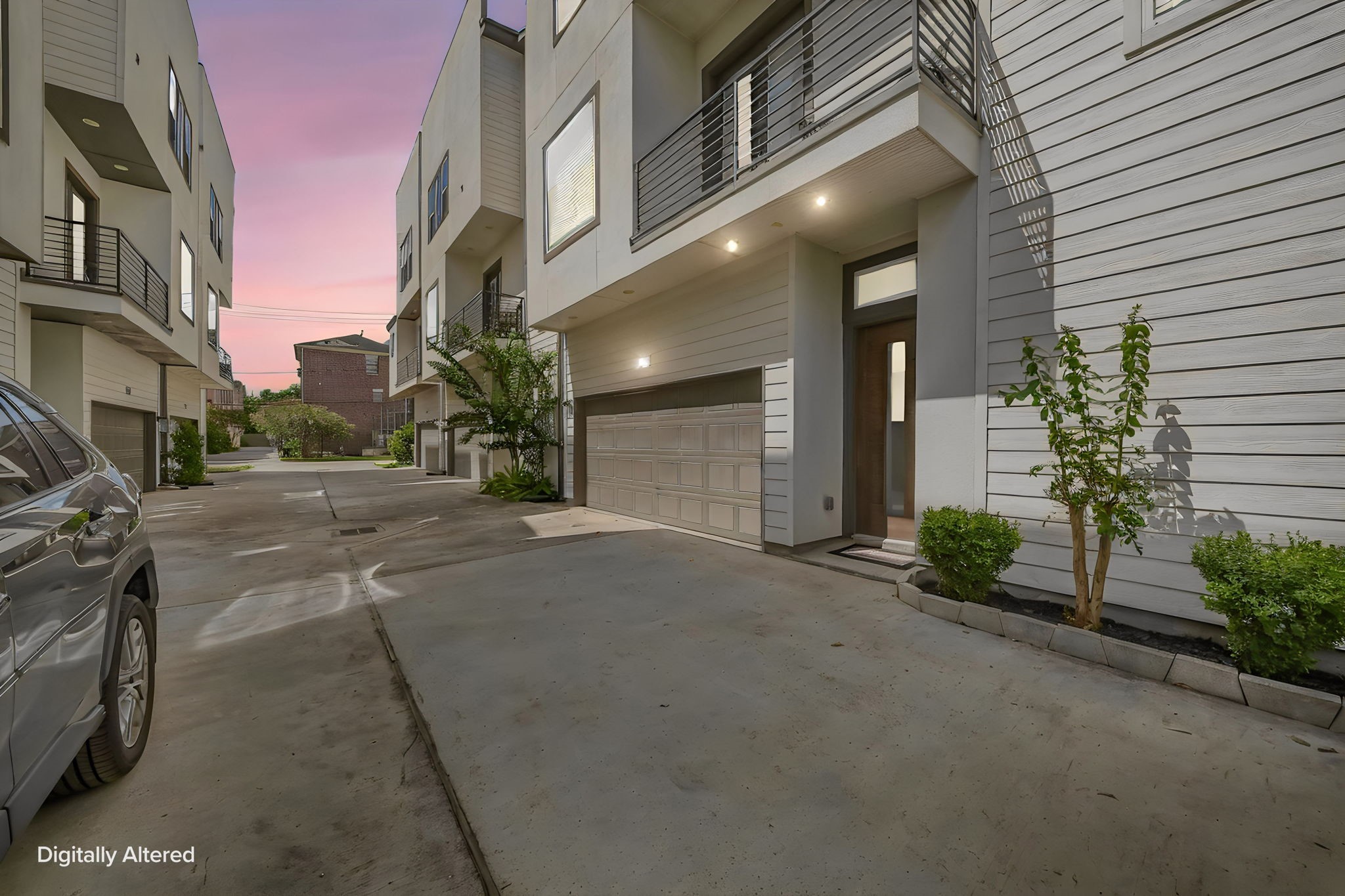 Welcoming exterior entry with attached two-car garage and additional off-street parking.