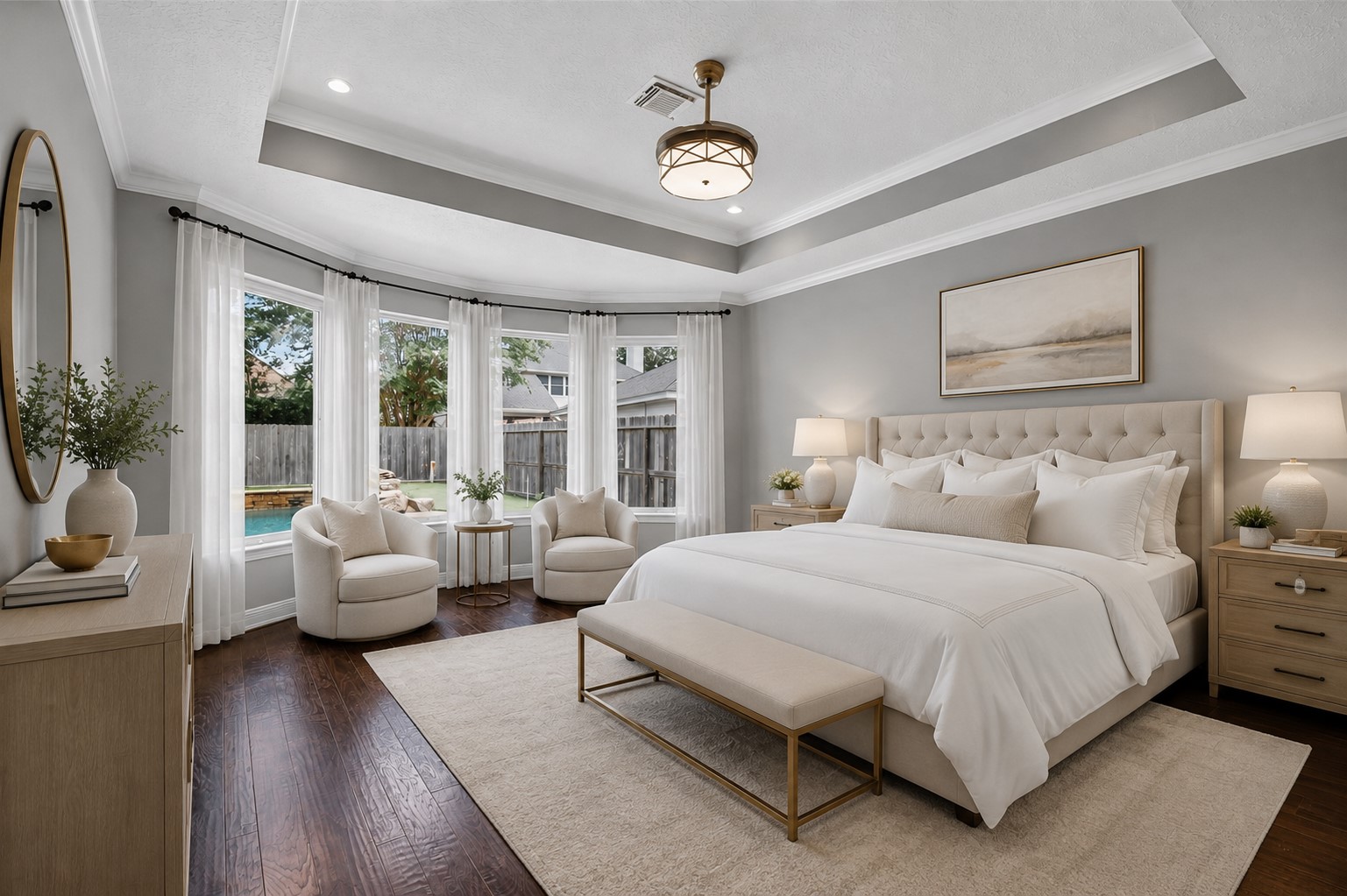 Primary bedroom virtually staged to showcase the tray ceiling, bay of windows, real wood floors and generous scale.