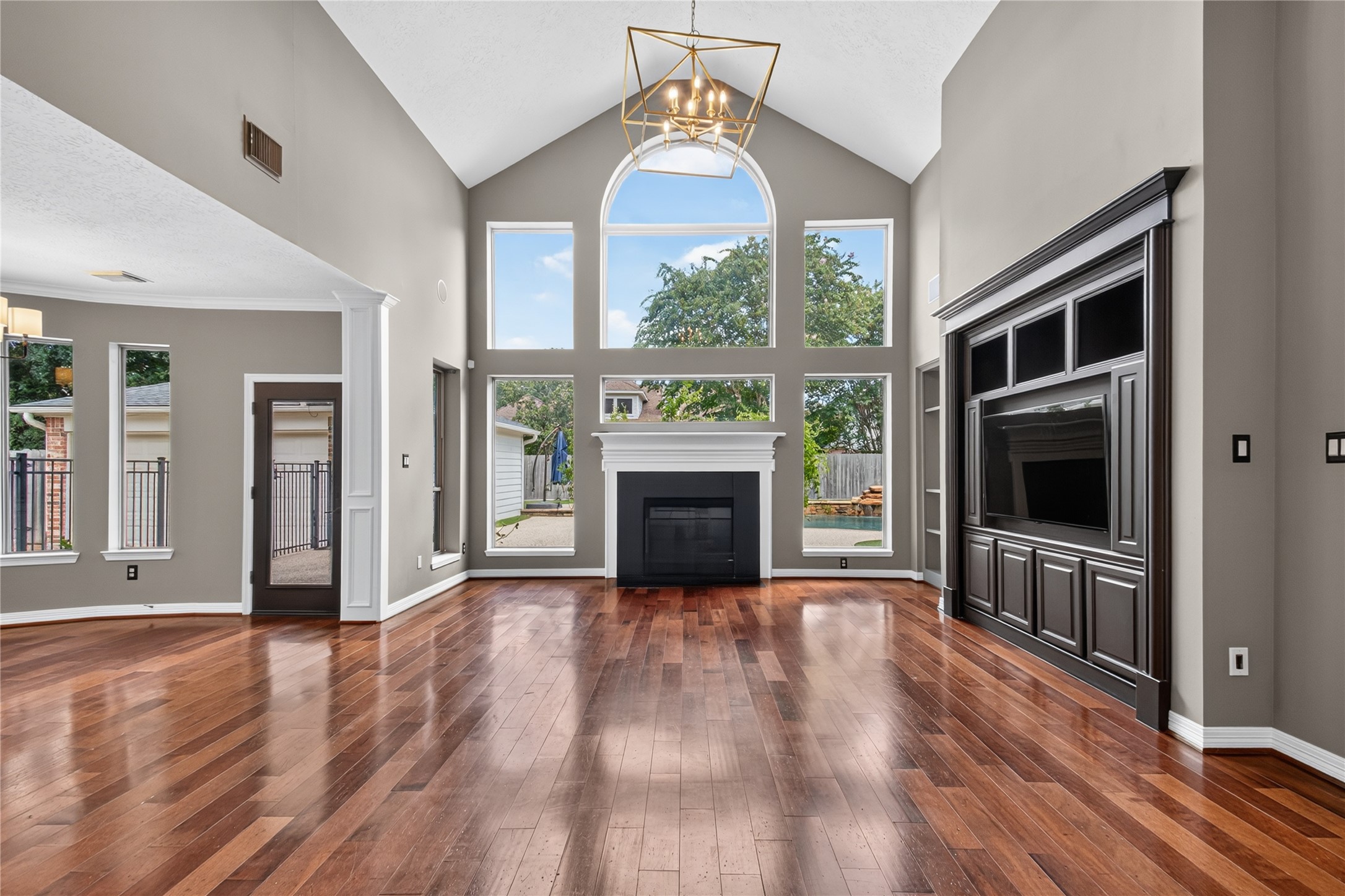 A dramatic wall of windows fills the two-story family room with natural light and views of the backyard.