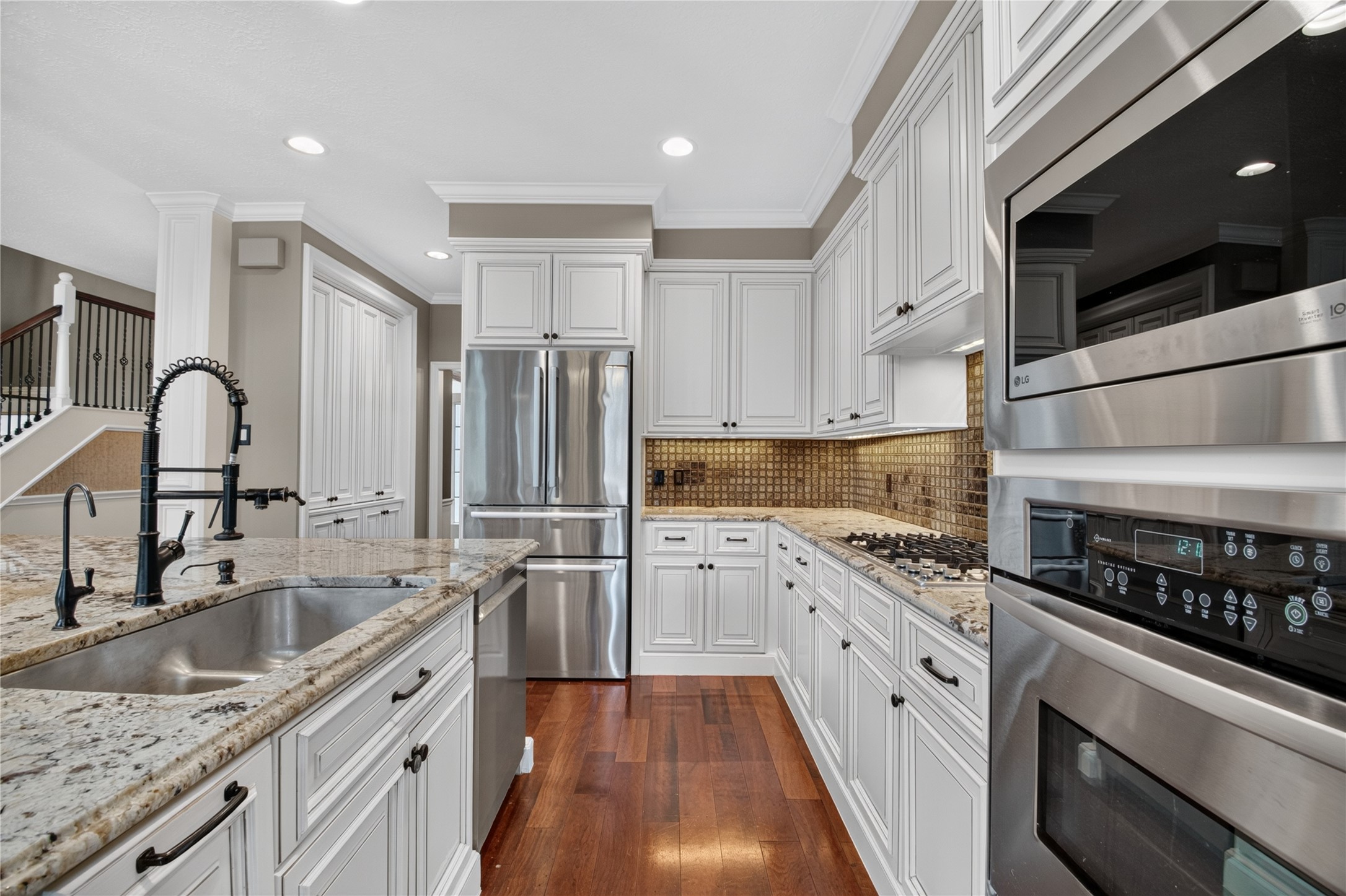 Bright kitchen with white cabinetry, granite counters, gas cooking and stainless appliances. Refrigerator included.