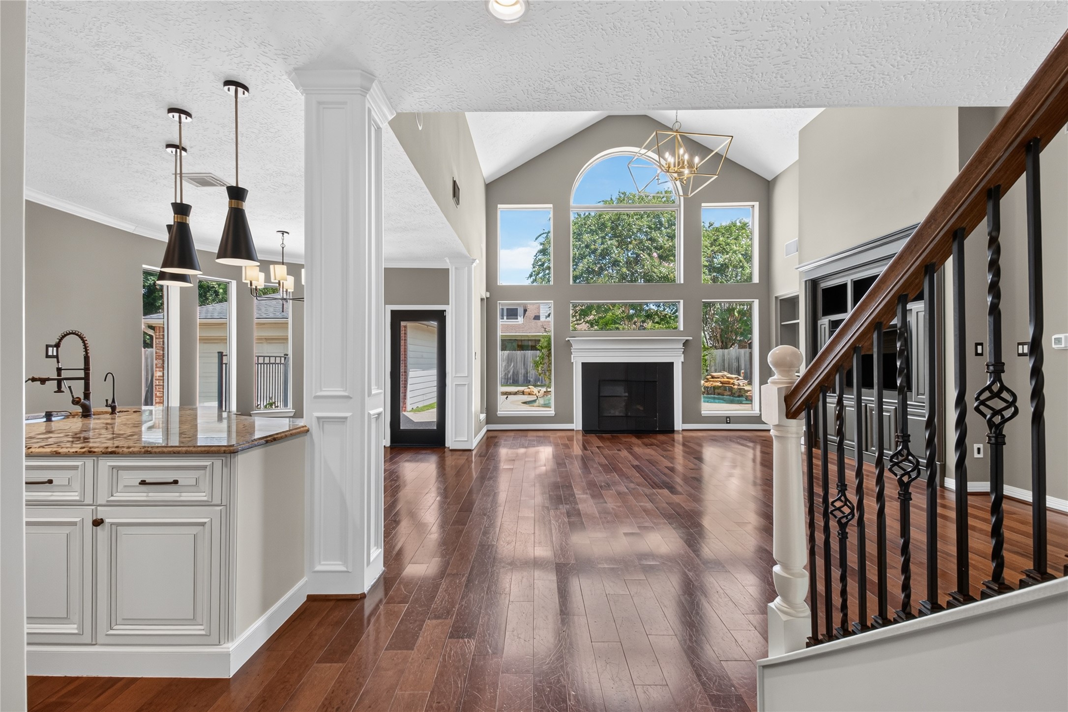 REAL WOOD FLOORS lead into the impressive two-story family room filled with natural light and backyard views.