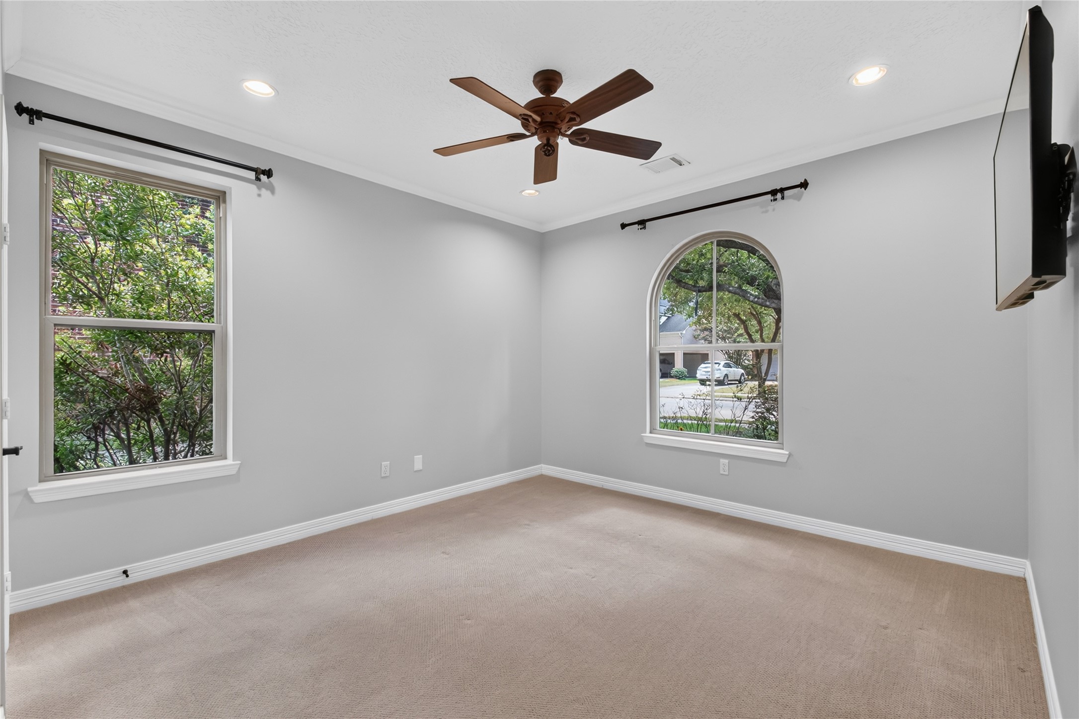Second Bedroom down with an arched window and convenient access to a full bathideal for guests or multi-generational living.