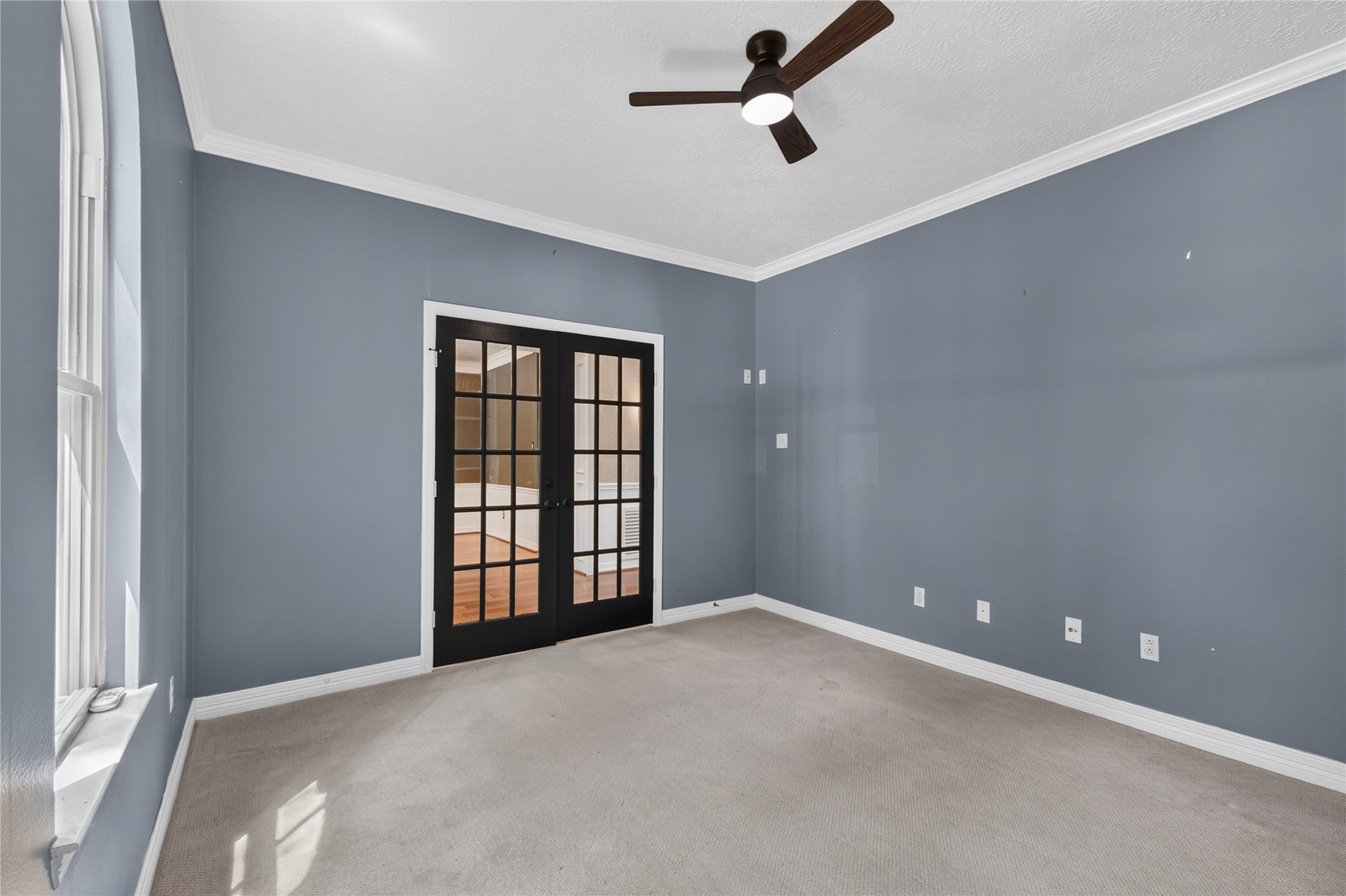 Private study with crown molding, natural light and French doors opening to the foyer.