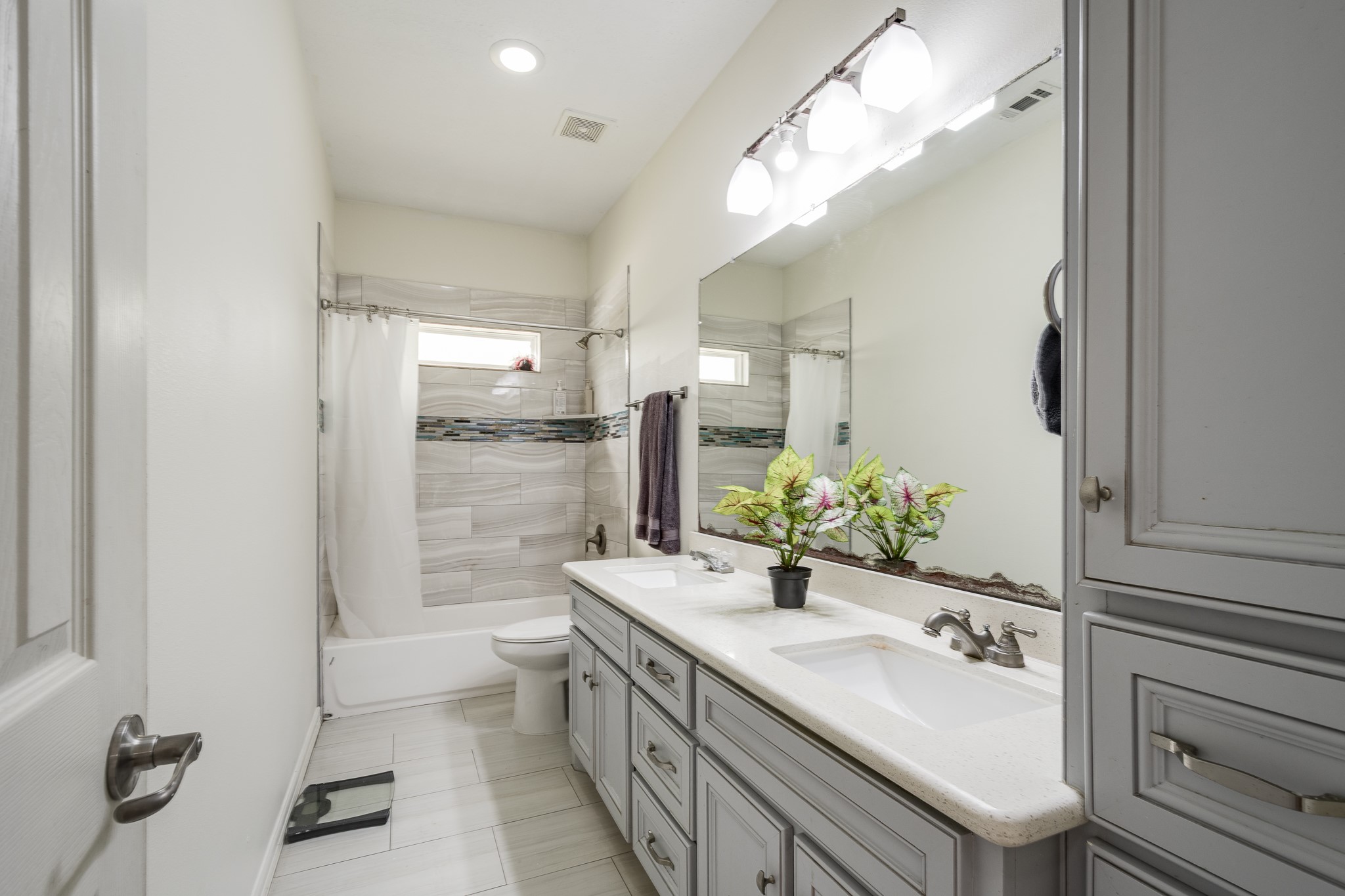 Upstairs full bathroom with double vanity and tub shower combo.