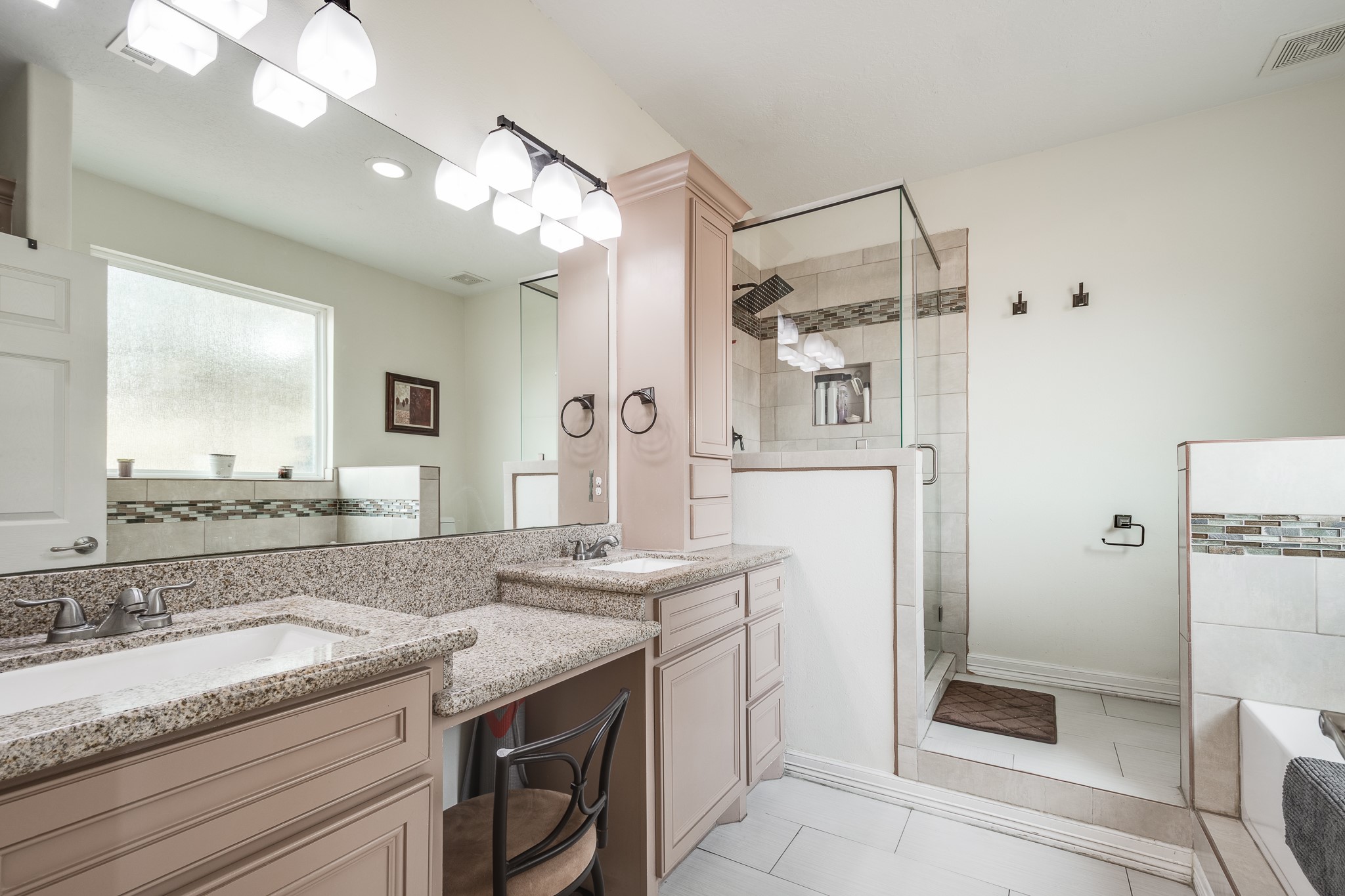 Primary bath with vanity, double sinks, separate tub and shower.