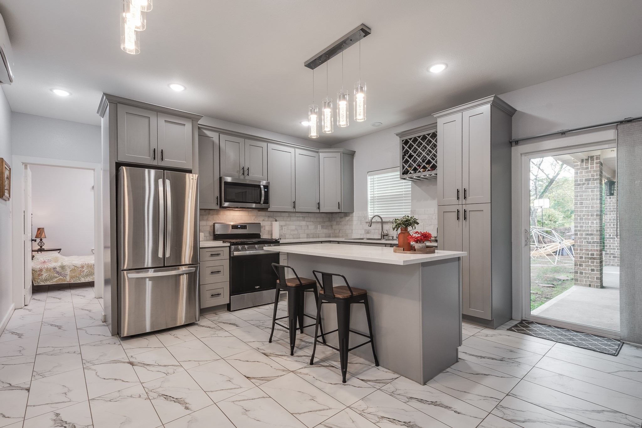 Full second kitchen with quartz countertops and recess lighting.