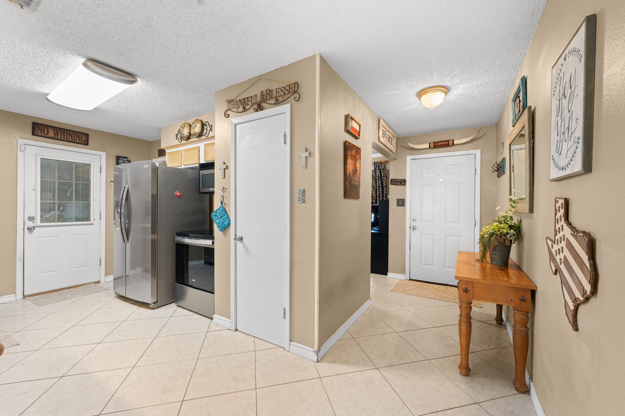 Functional layout with easy access between the kitchen, entryway, and main living areas, creating a seamless everyday flow. Stainless steel appliances, ample storage, and tile flooring add both style and practicality to the space.