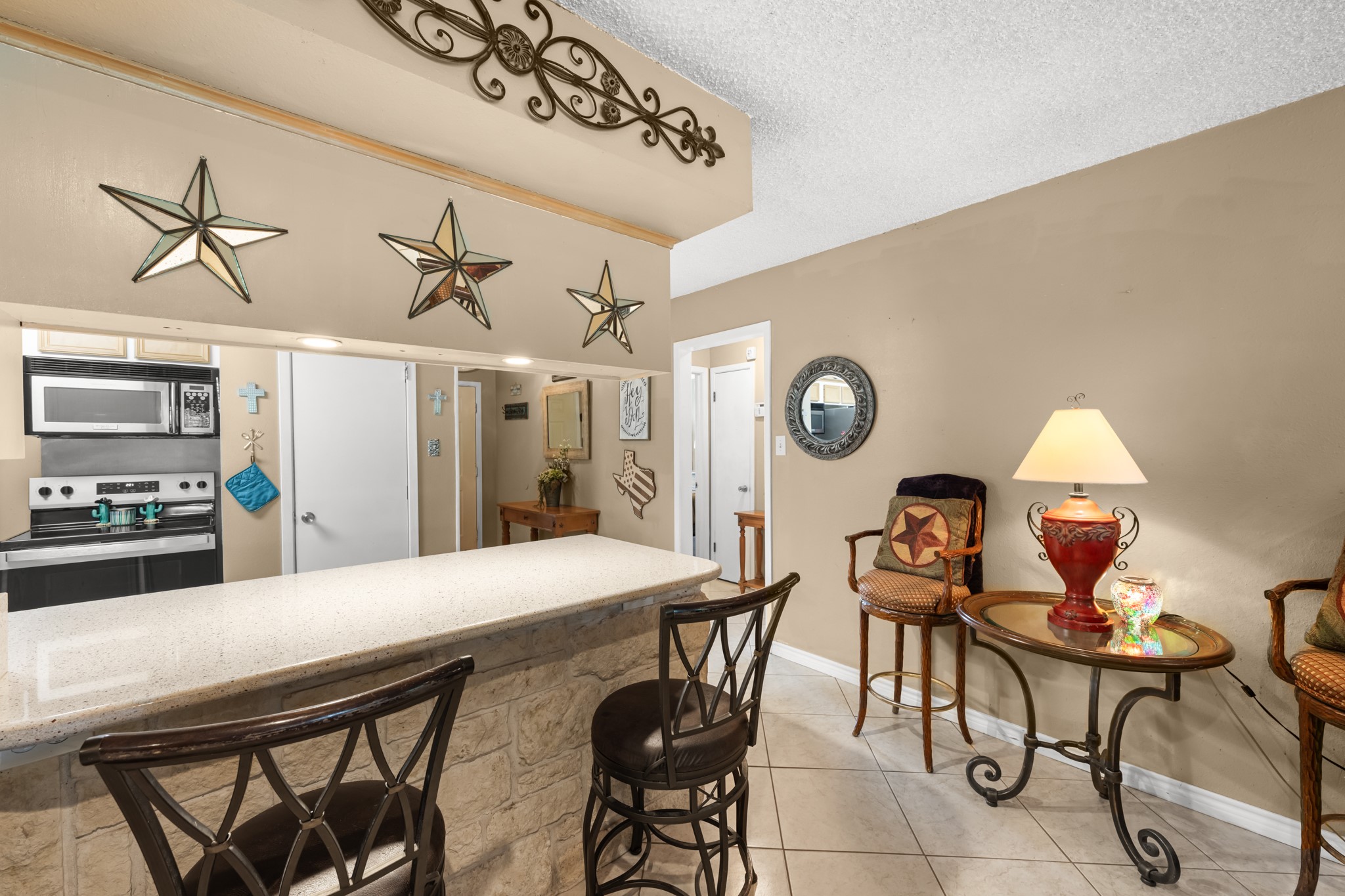 Oversized breakfast bar with stone detailing and seating creates the perfect space for casual dining or gathering with guests. The open-concept design provides a seamless connection between the kitchen and main living areas for easy everyday living.