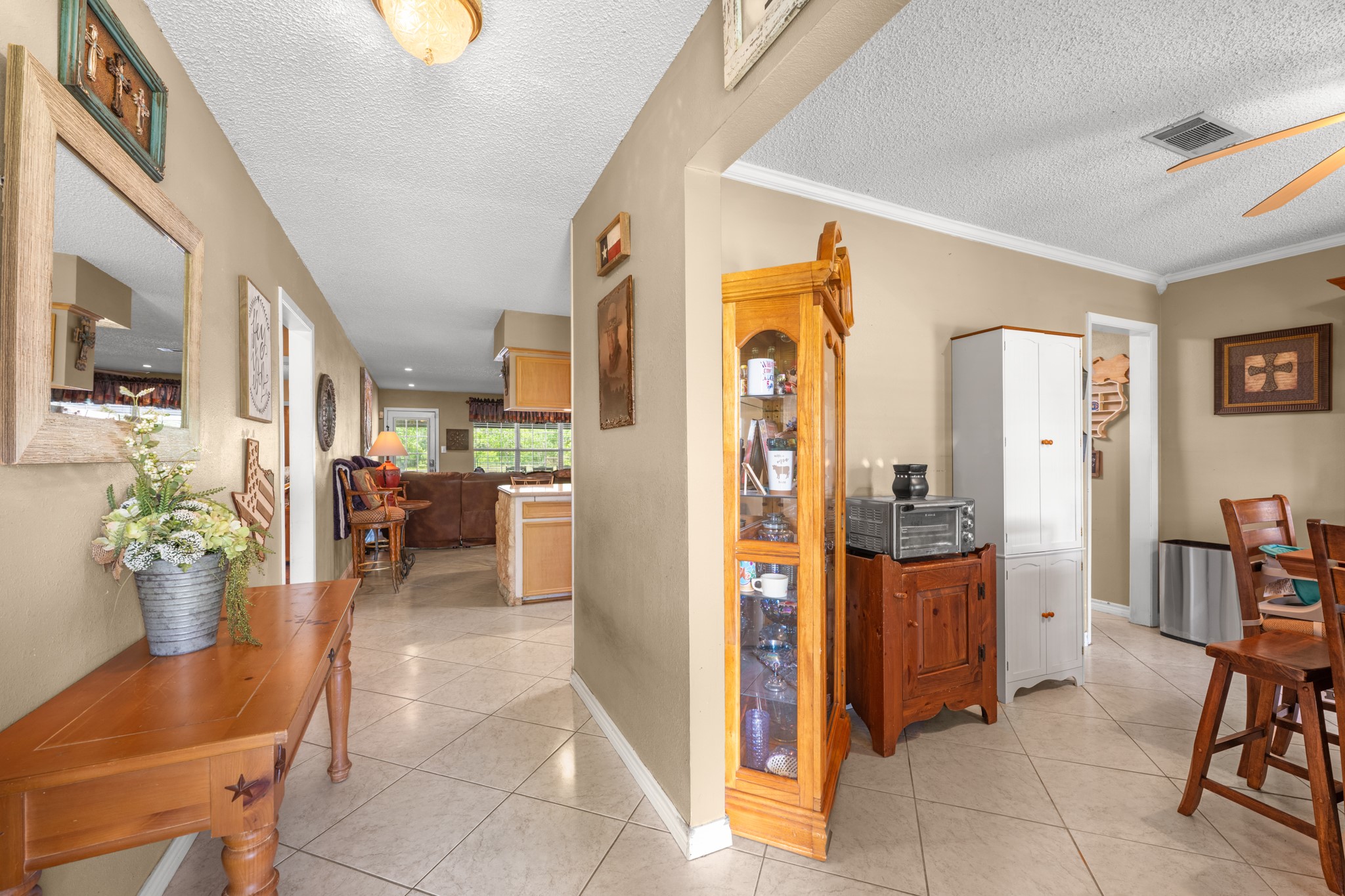Welcoming entryway with durable tile flooring and an open flow into the dining and living spaces. Neutral tones and abundant natural light create a warm, inviting atmosphere throughout the home.