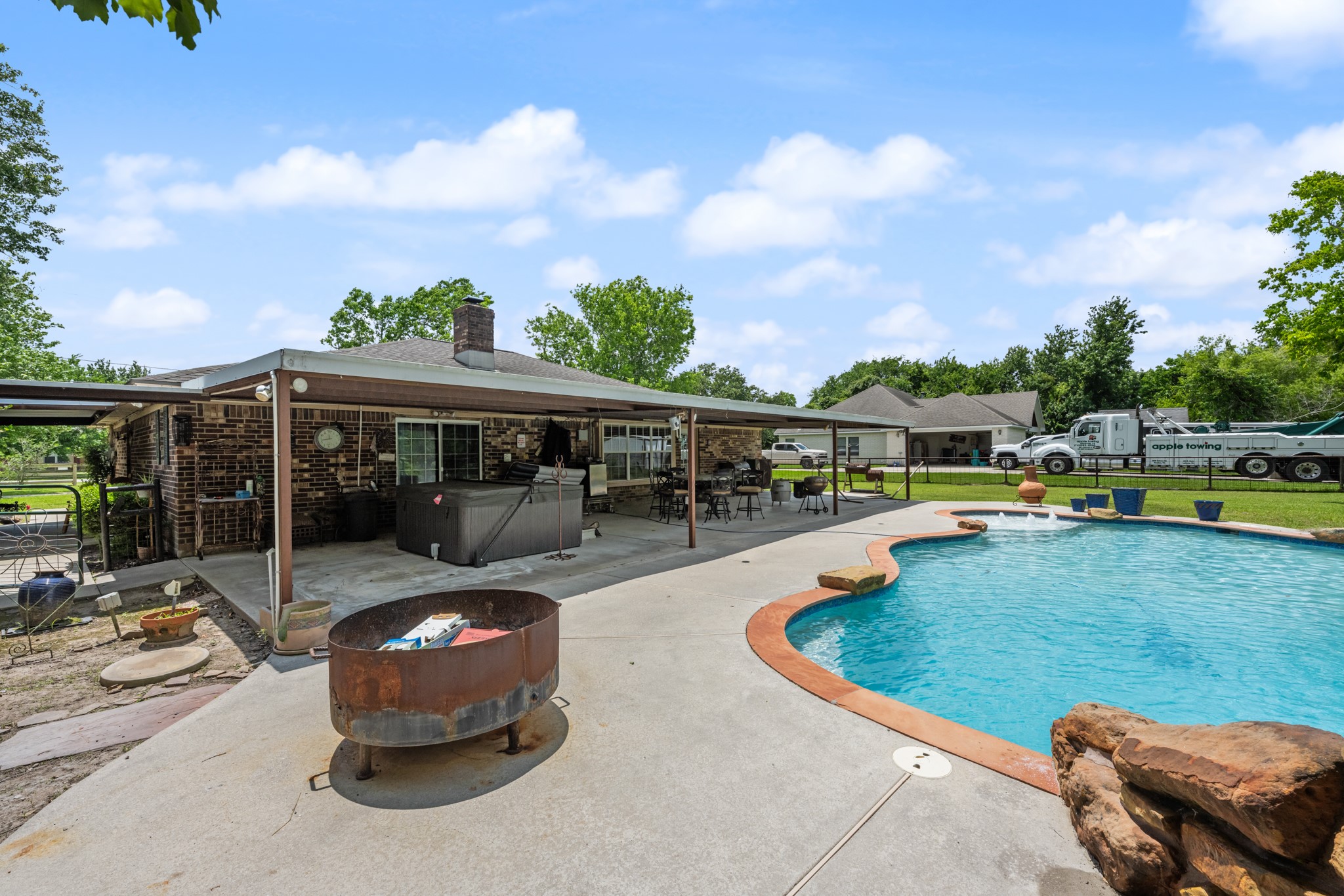 Expansive backyard retreat featuring a sparkling in-ground pool, oversized covered patio, and multiple spaces for outdoor dining and entertaining. The setup is ideal for relaxing weekends, gatherings, and enjoying the spacious yard.
