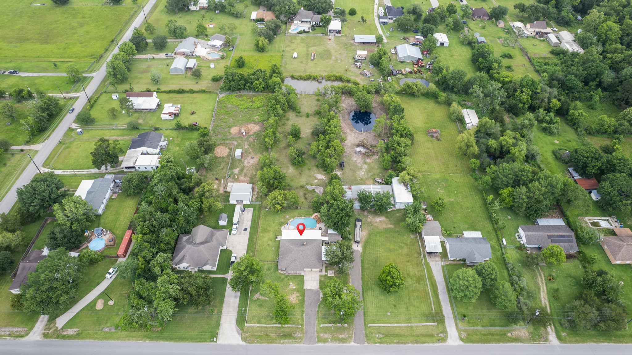 Expansive aerial view highlighting the propertys generous lot size, mature trees, private backyard oasis, and surrounding open space. This birds-eye perspective showcases the peaceful setting and ample room for outdoor living and recreation.